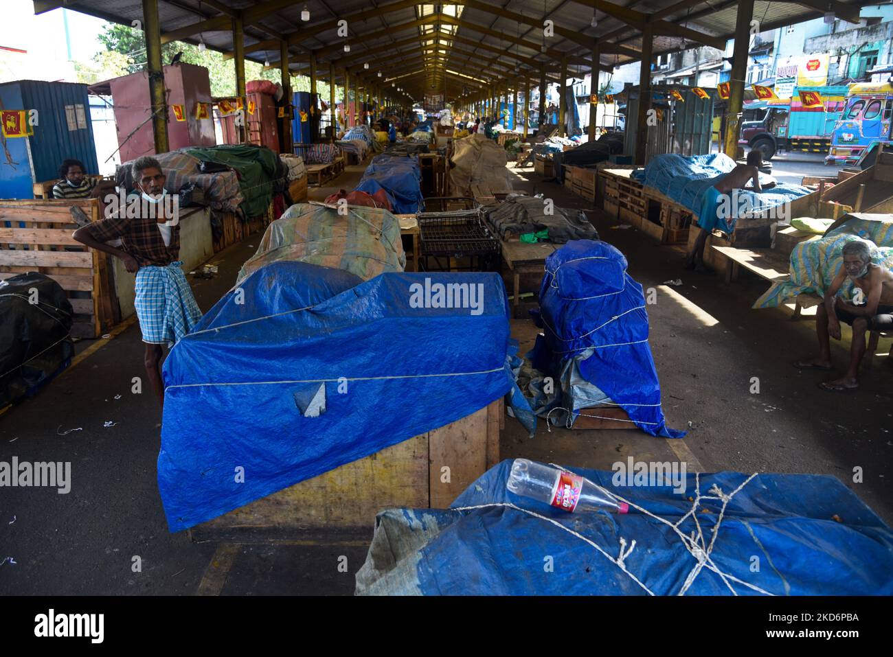 Sri Lankans walk on a deserted street at a wholesale market during