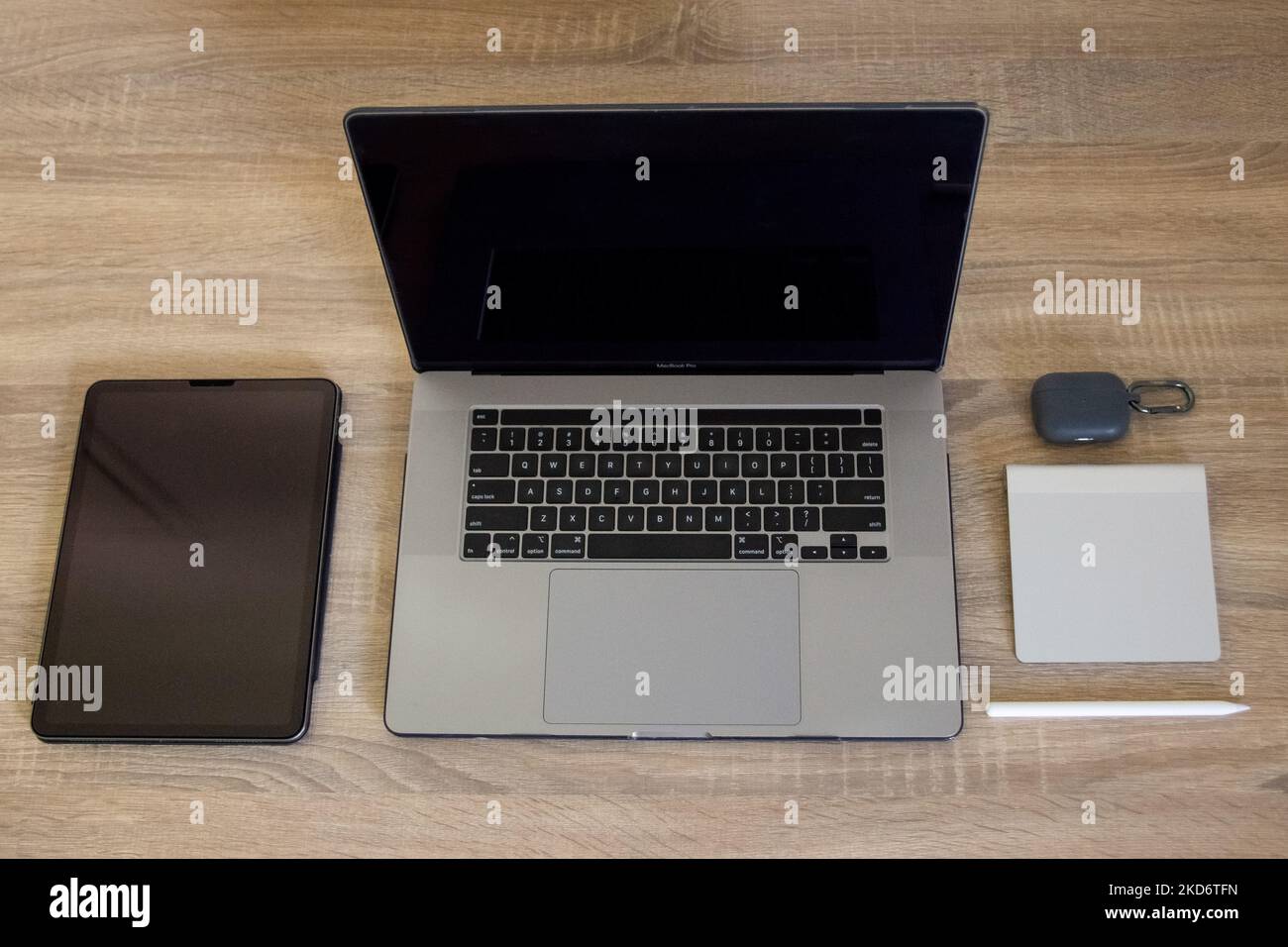 An Macintosh (Apple) laptop, a graphic pen tablet with a pen, a