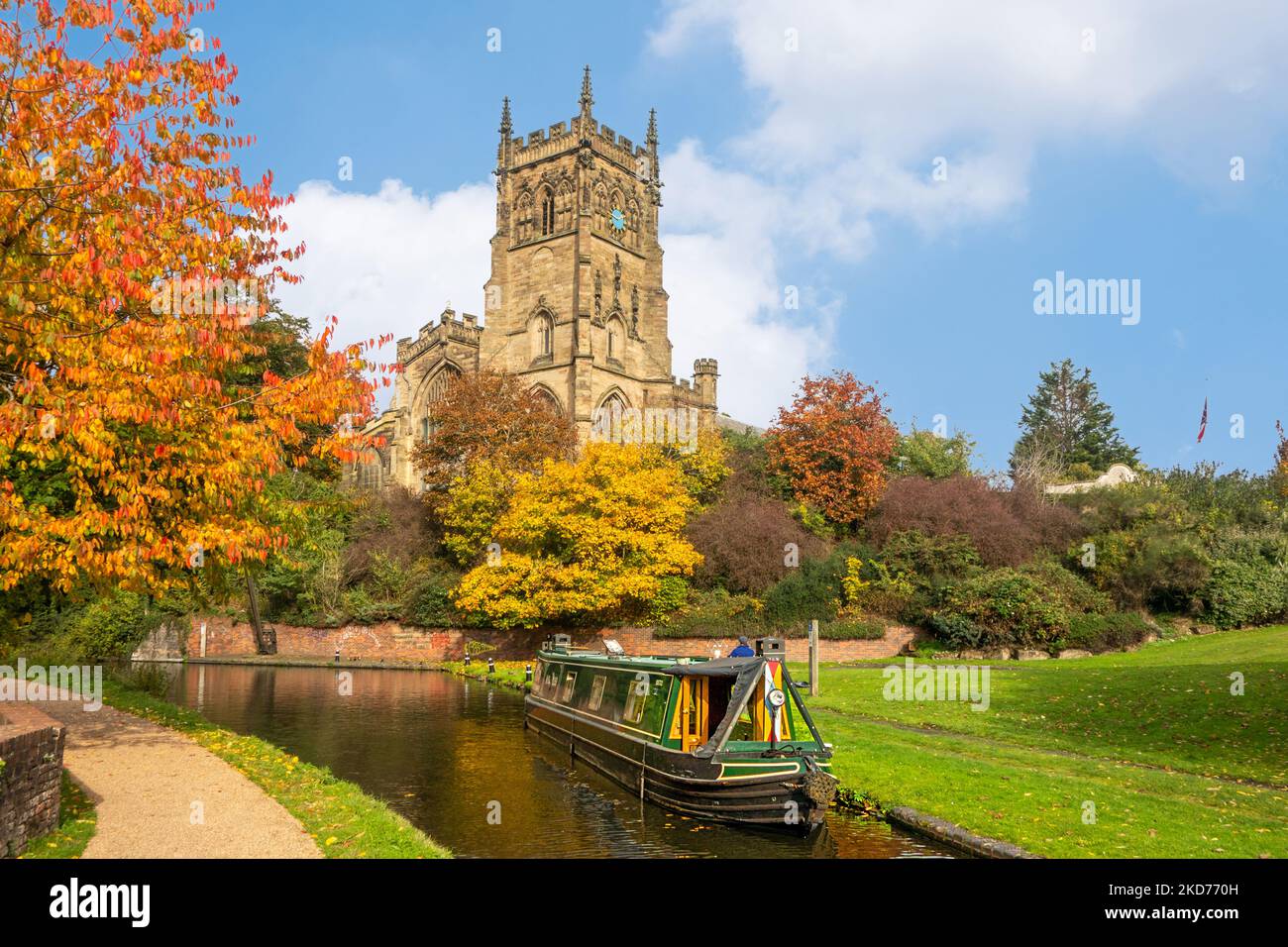 Narrowboat on the Staffordshire and Worcester canal by St Mary's and  all Saints church in the Worcestershire town of Kidderminster during the Autumn Stock Photo