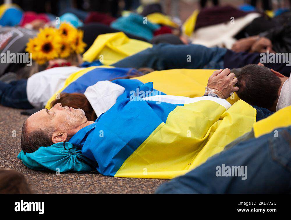 Protesters lie on the ground as they reenact the murder of 163 people in Bucha during a rally at the White House for Ukraine. Hundreds of people gathered to demand that the United States and the West stop making promises and increase actions for Ukraine. (Photo by Allison Bailey/NurPhoto) Stock Photo
