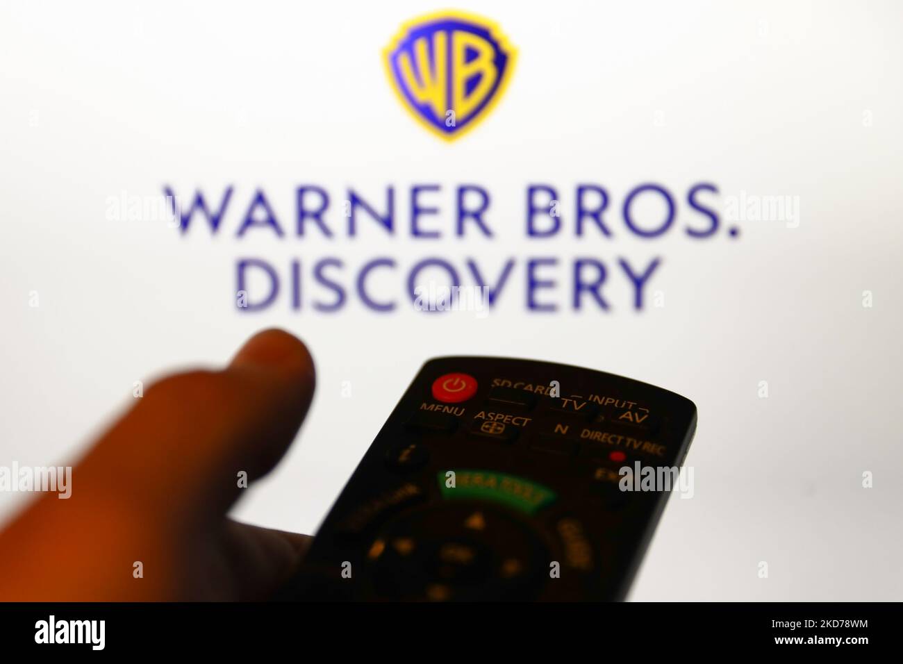 Warner Bros. Discovery logo displayed on a screen and a tv remote control are seen in this illustration photo taken in Krakow, Poland on April 9, 2022. (Photo by Jakub Porzycki/NurPhoto) Stock Photo