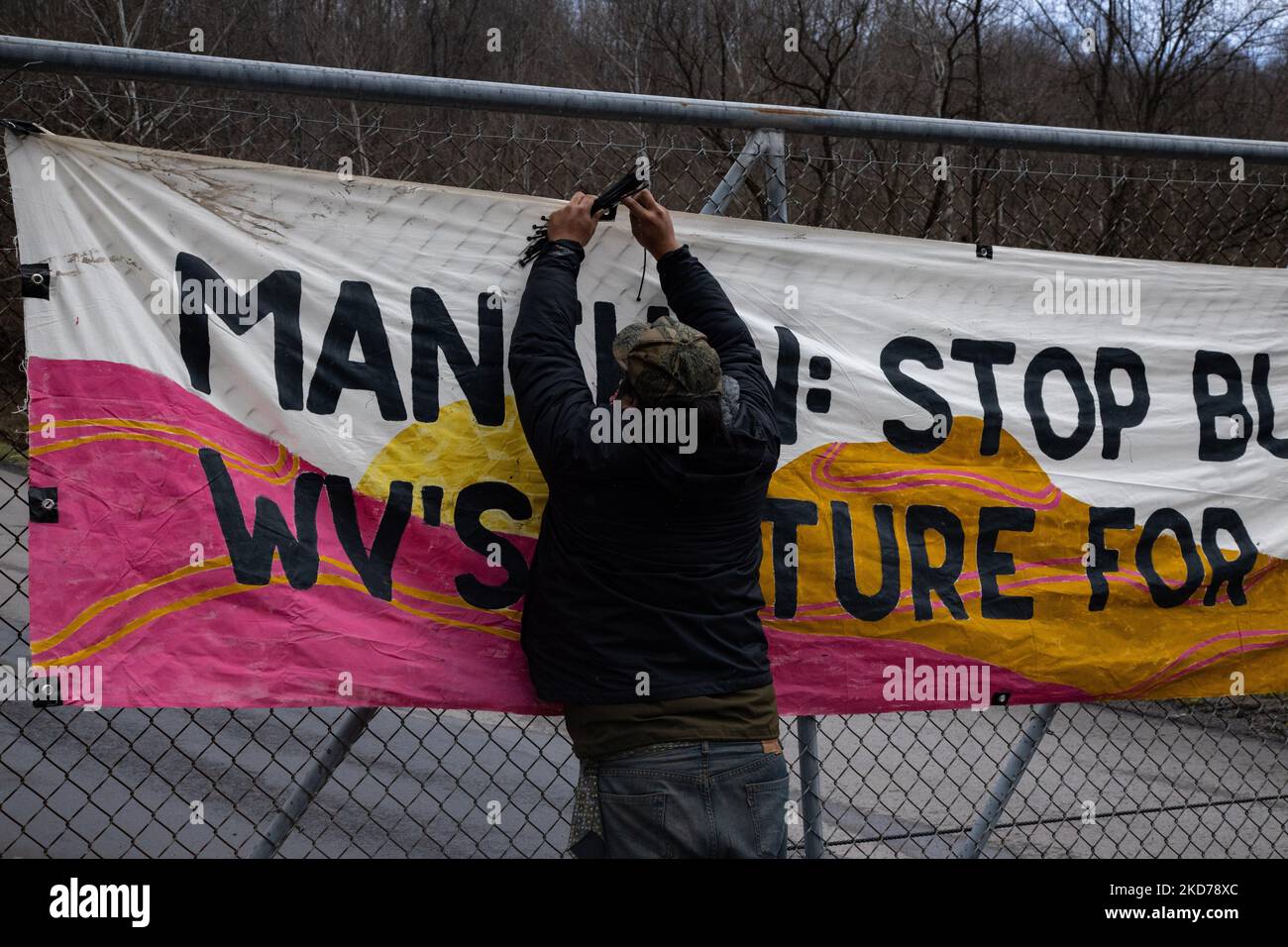 A climate activist hangs a banner at the entrance to the Grant Town