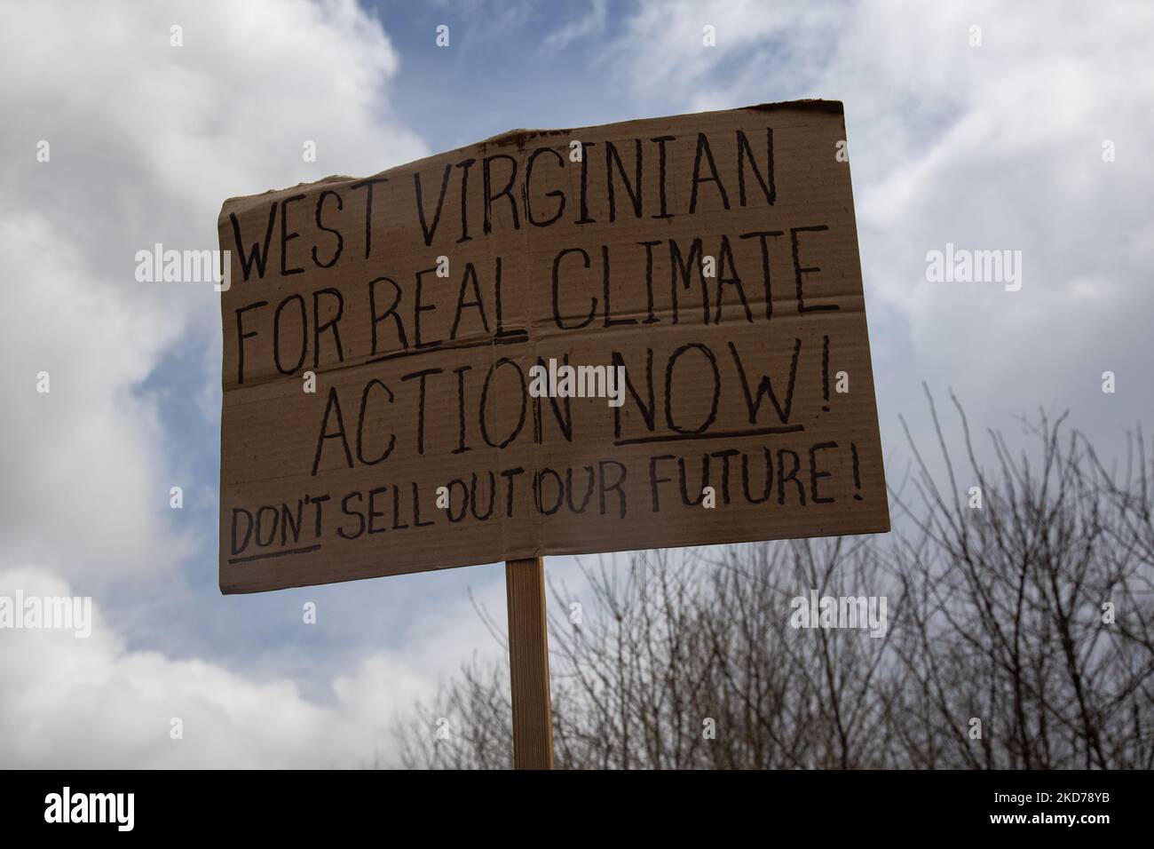 A sign is held as climate activists gather to block the entrance to the