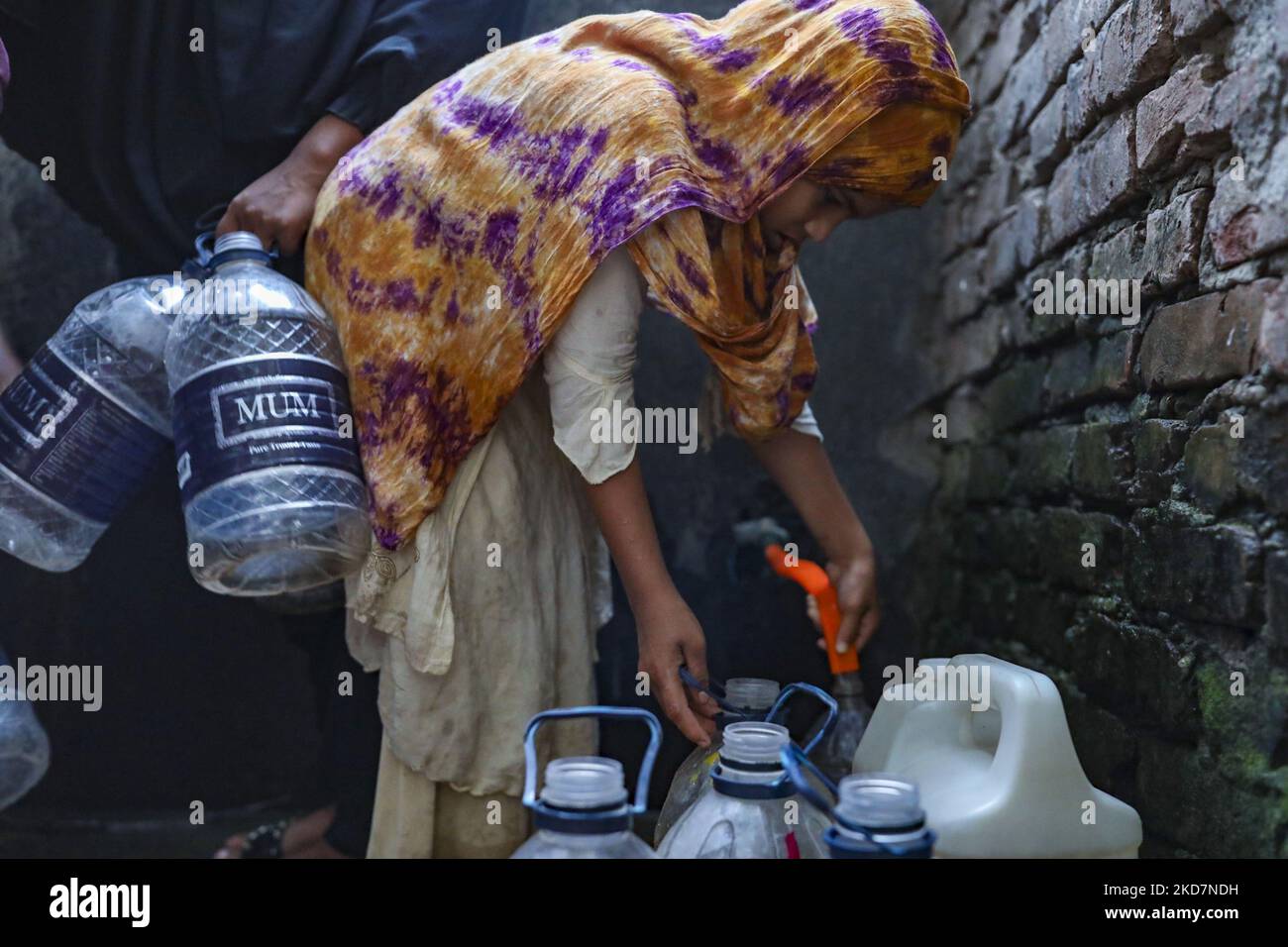 People collect drinking water from a Buddhist Temple before iftar during Ramadan in Dhaka, Bangladesh on April 15, 2022. During the summer Bangladeshi urban people had faced to pure drinking water crisis. (Photo by Kazi Salahuddin Razu/NurPhoto) Stock Photo