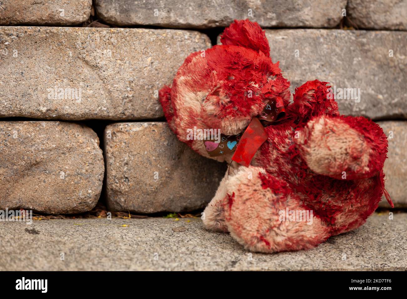 A teddy bear covered in fake blood sits outside the residence of 