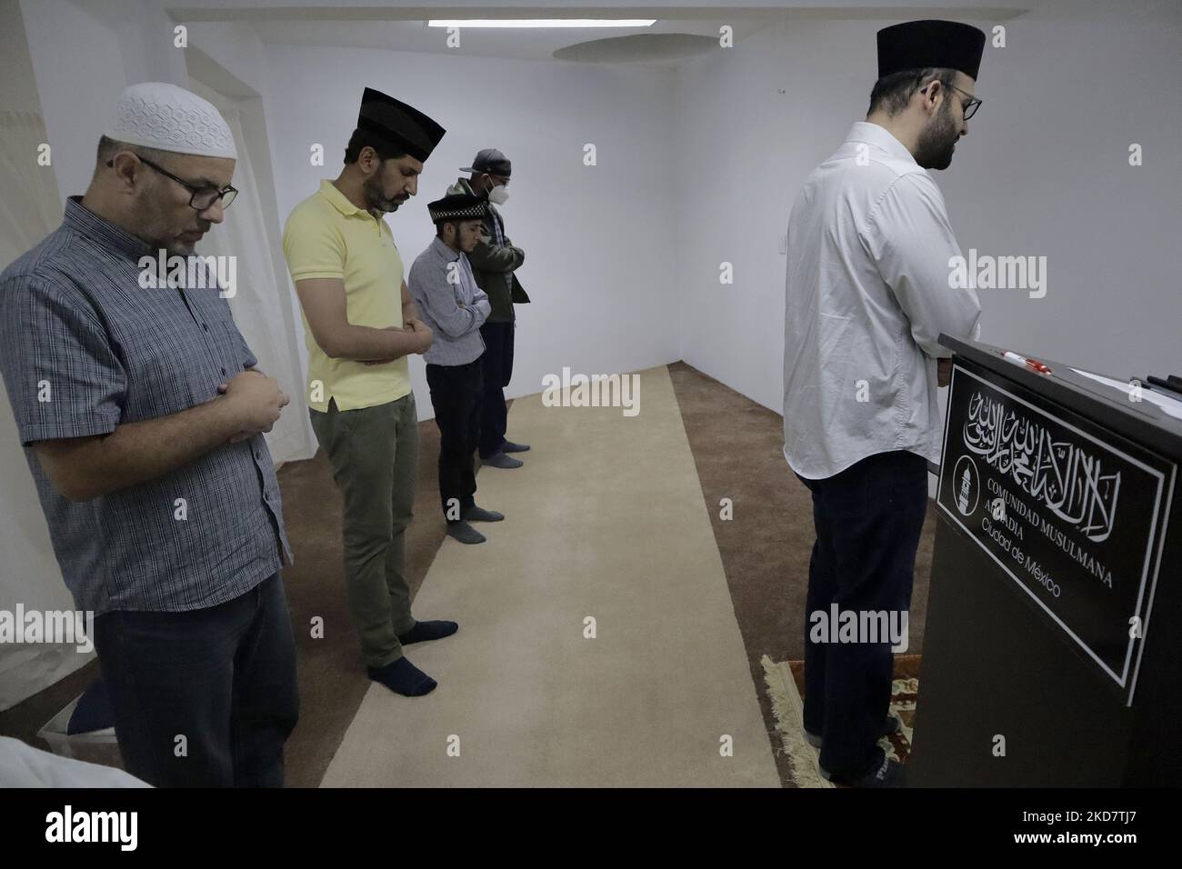 On the right, Noman Rana, Imam and mosque manager in Mexico City, in front of a group of members of the Muslim community during prayer after fasting as part of Ramadan in order to grow spiritually and establish stronger relationships with Allah. (Photo by Gerardo Vieyra/NurPhoto) Stock Photo