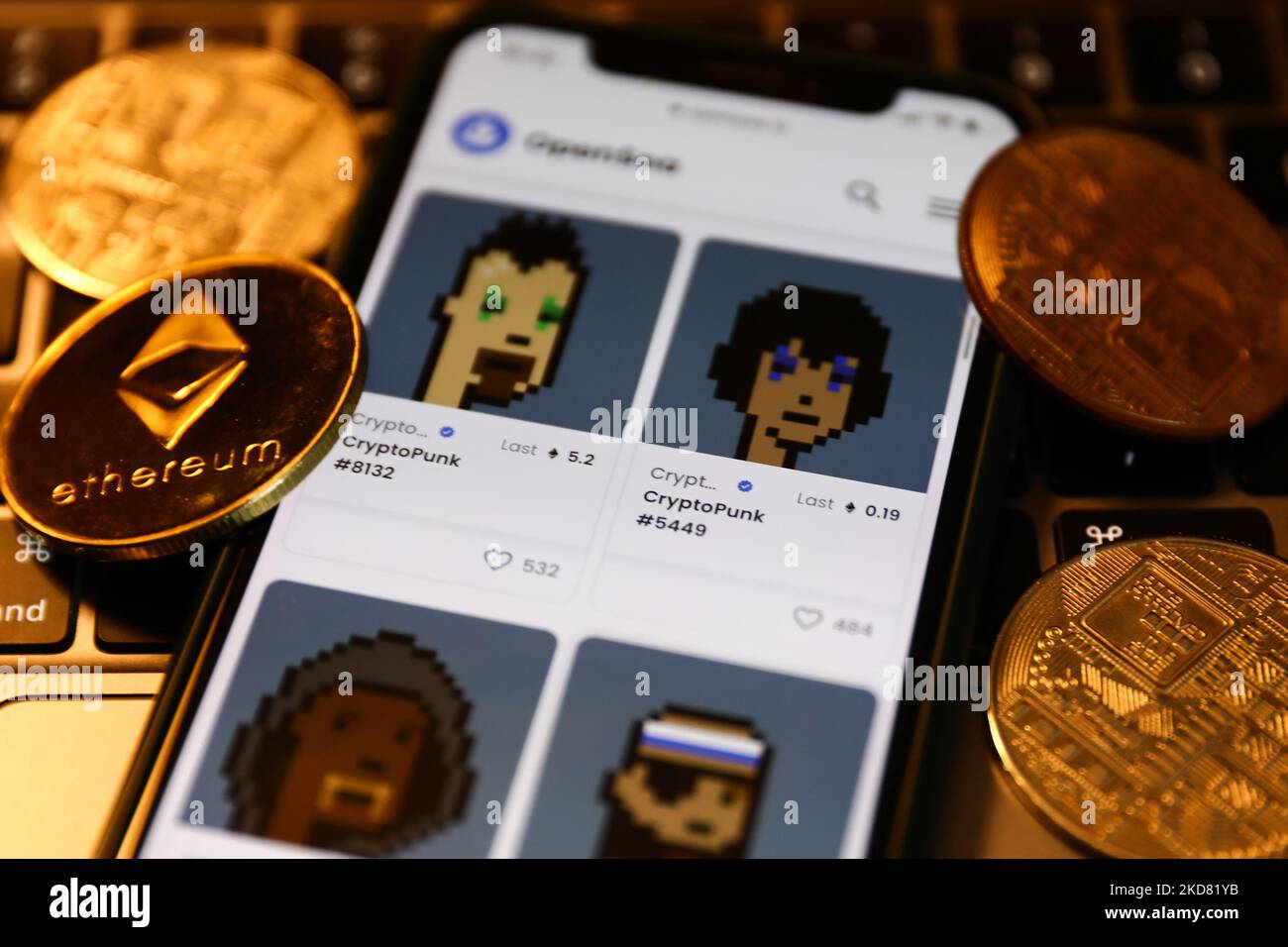 CryptoPunks collection in OpenSea displayed on a phone screen, representation of cryptocurrencies and a laptop keyboard are seen in this illustration photo taken in Krakow, Poland on April 19, 2022. (Photo by Jakub Porzycki/NurPhoto) Stock Photo