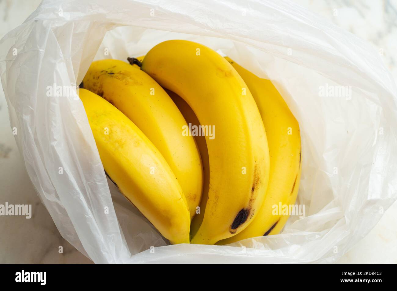 https://c8.alamy.com/comp/2KD84C3/goinia-goias-brazil-november-05-2022-a-bunch-of-bananas-in-a-plastic-bag-on-the-table-2KD84C3.jpg