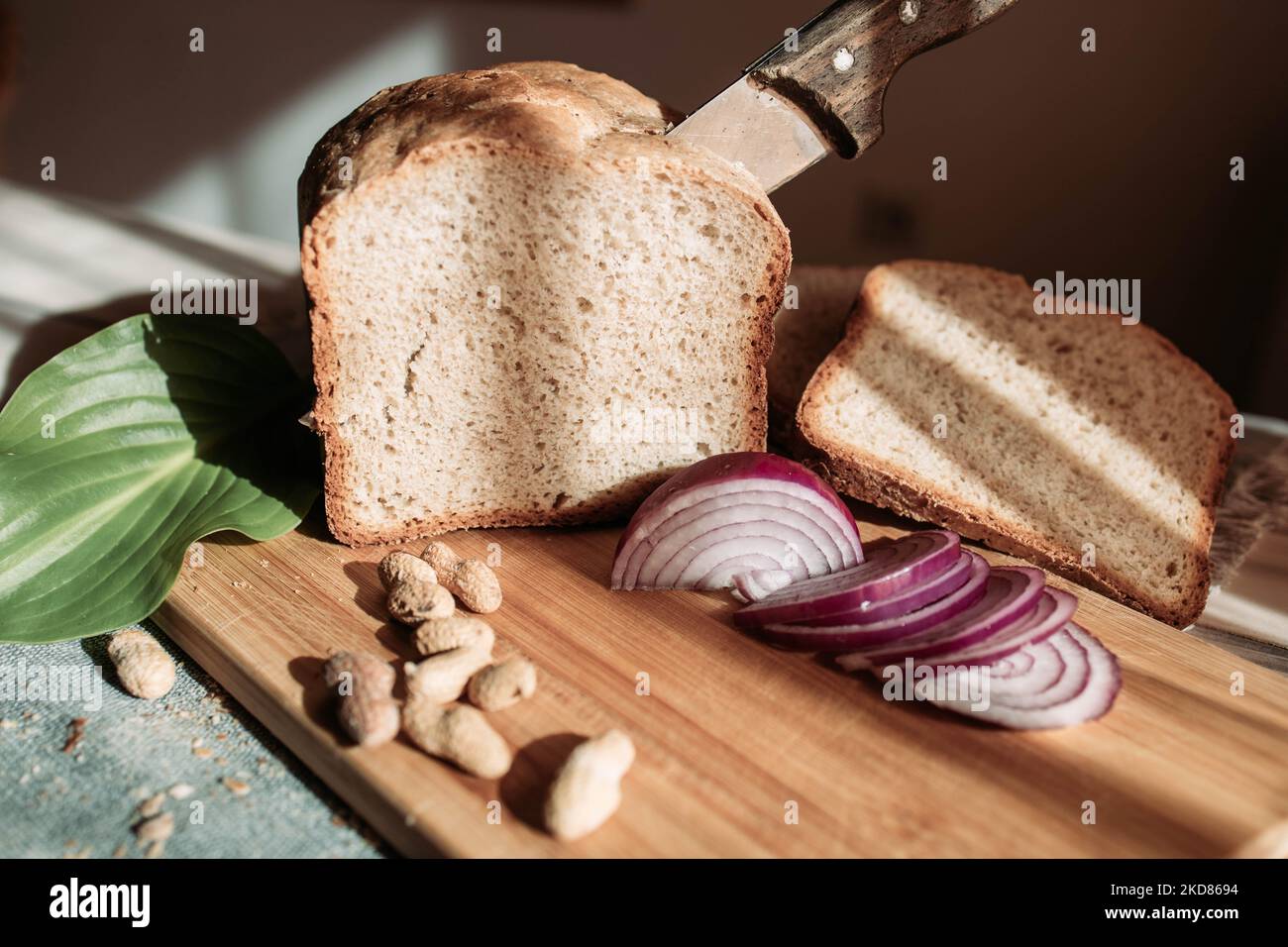 Homemade wheat flour bread with peanuts and red onion on the table