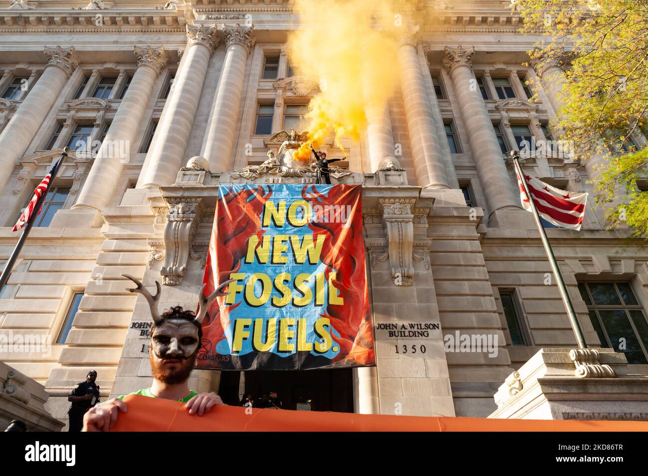 Protest Against Fosil A member of Extinction Rebellion releases orange smoke after dropping a ...