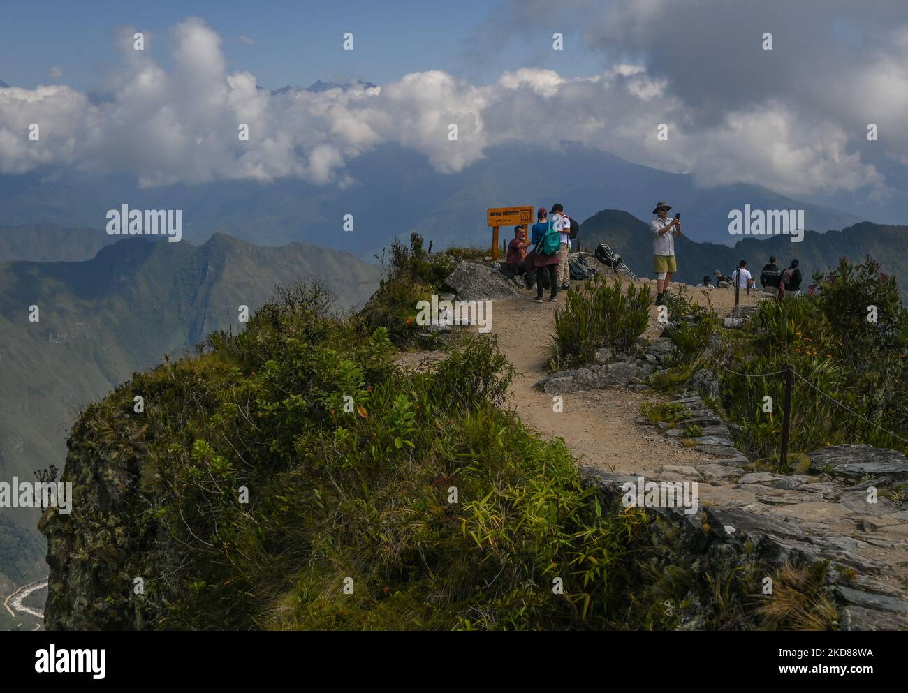 Tourists enjoy a view of of the ancient Inca city of Machu Picchu located in the Andes at an altitude of 2,430 meters (7,970 feet) from the top of Machu Picchu mountain (3,061 metres). The most famous icon of the Inca civilization was declared a Peruvian Historical Sanctuary in 1981, a UNESCO World Heritage Site in 1983, and in 2007 was then declared one of the Seven New Wonders of the World. On Wednesday, 20 April 2022, in Historic Sanctuary of Machu Picchu, Urubamba Province, Peru. (Photo by Artur Widak/NurPhoto) Stock Photo