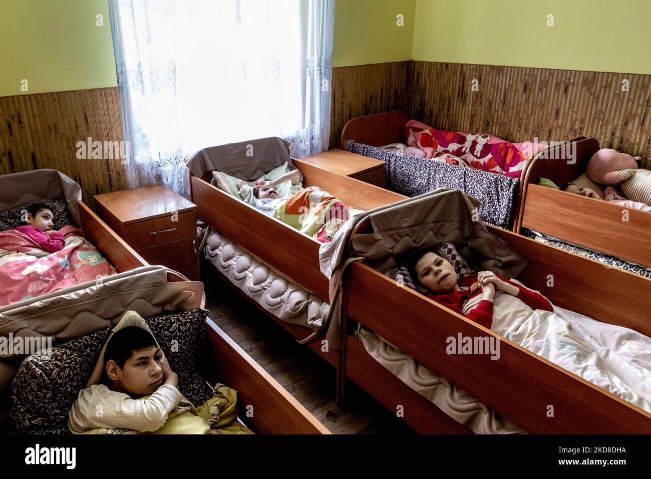 Young Ukrainian women with seviere learning disabilities rest in beds in a Center for women and girls with learning disabilities run by Greek Catholic church in Bukova, Lviv Oblast Ukraine on April 25, 2022. As the Russian Federation invaded Ukraine two months ago, the conflict caused that places like the Centre in Bukova become even more isolated and underfunded. (Photo by Dominika Zarzycka/NurPhoto) Stock Photo