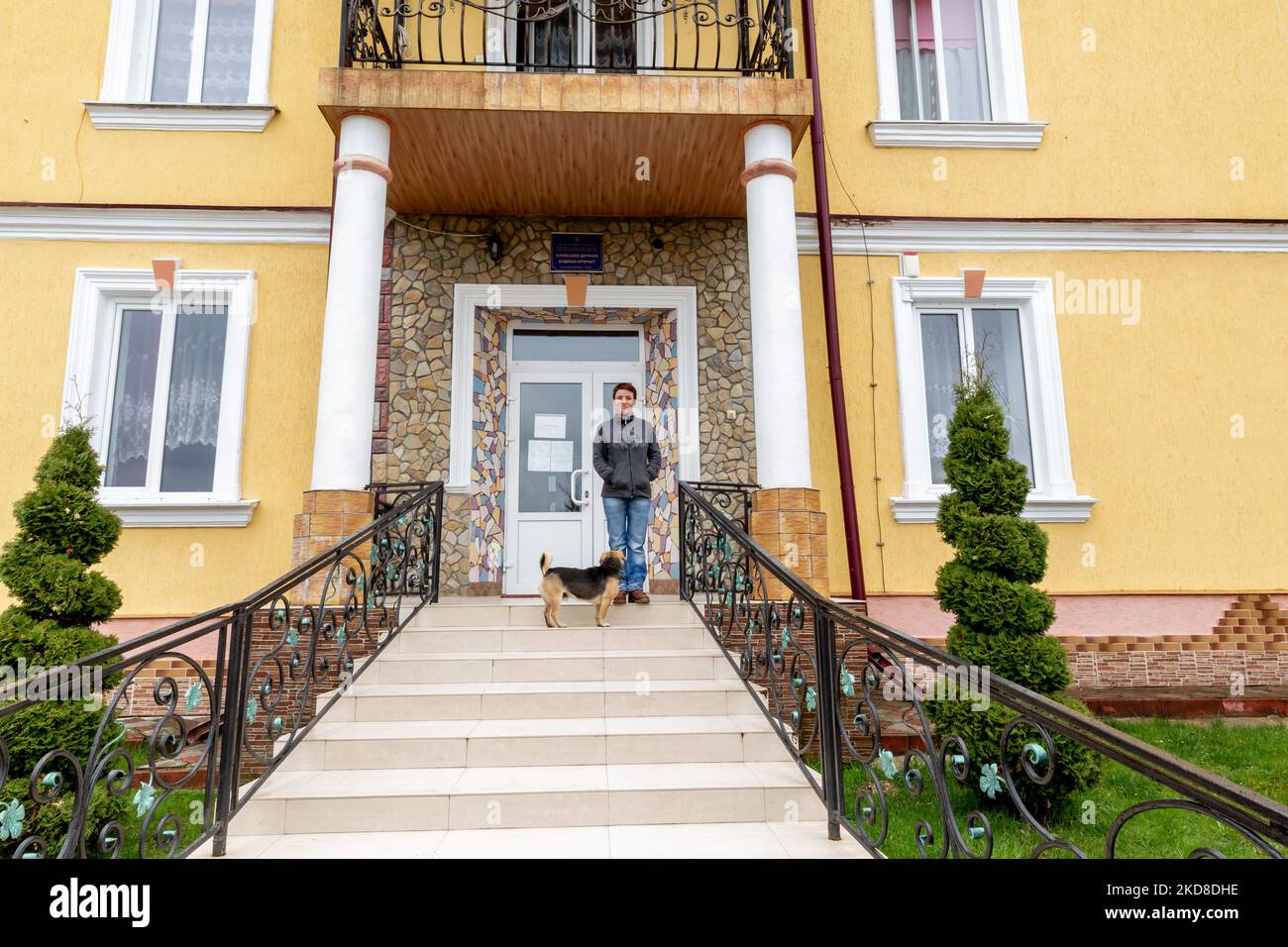 A young Ukrainian woman with learning disabilities stands in front of a Center for women and girls with learning disabilities run by Greek Catholic church in Bukova, Lviv Oblast Ukraine on April 25, 2022. As the Russian Federation invaded Ukraine two months ago, the conflict caused that places like the Centre in Bukova become even more isolated and underfunded. (Photo by Dominika Zarzycka/NurPhoto) Stock Photo