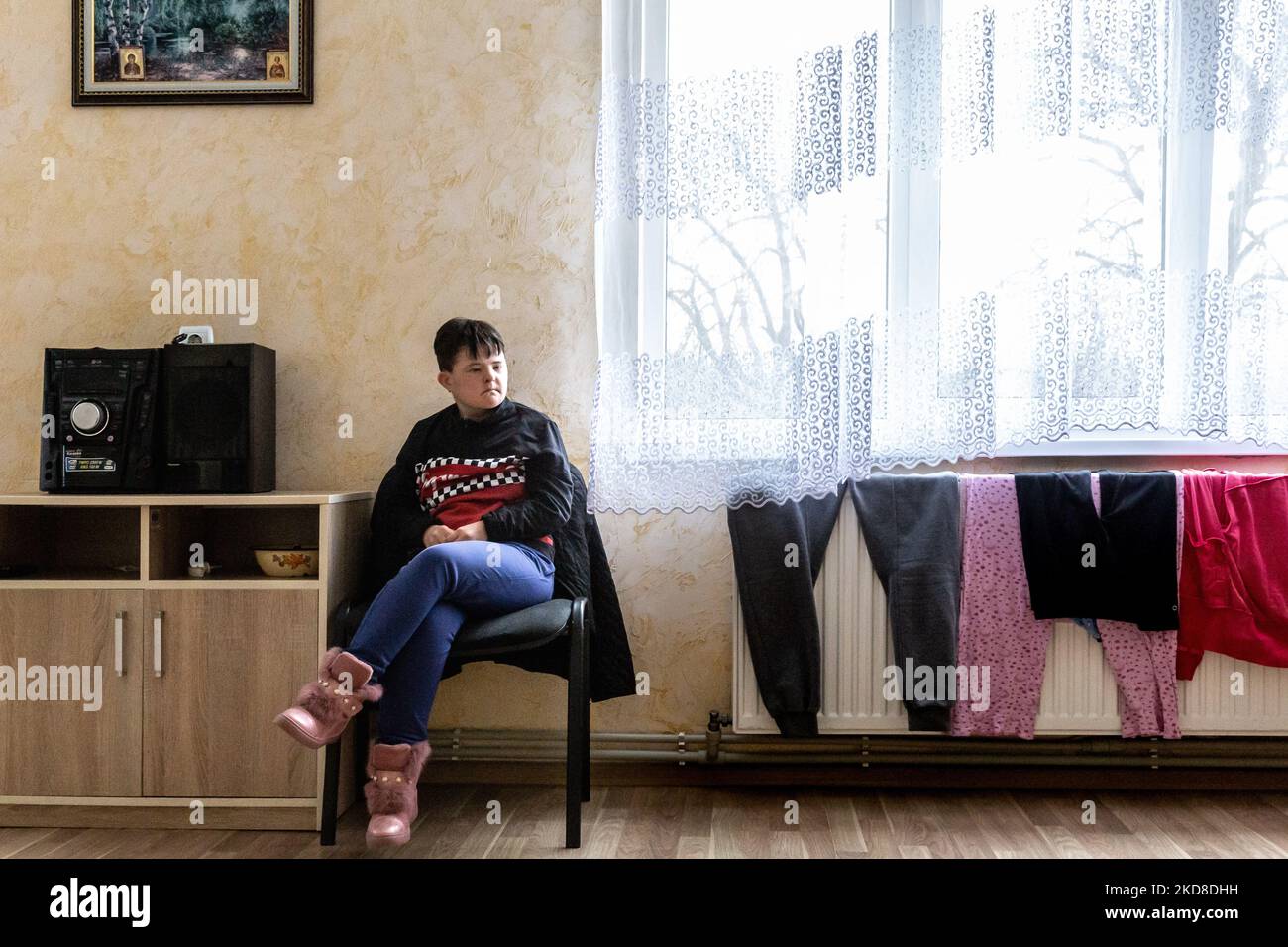 A young Ukrainian woman with learning disabilities rests in a common room in a Center for women and girls with learning disabilities run by Greek Catholic church in Bukova, Lviv Oblast Ukraine on April 25, 2022. As the Russian Federation invaded Ukraine two months ago, the conflict caused that places like the Centre in Bukova become even more isolated and underfunded. (Photo by Dominika Zarzycka/NurPhoto) Stock Photo