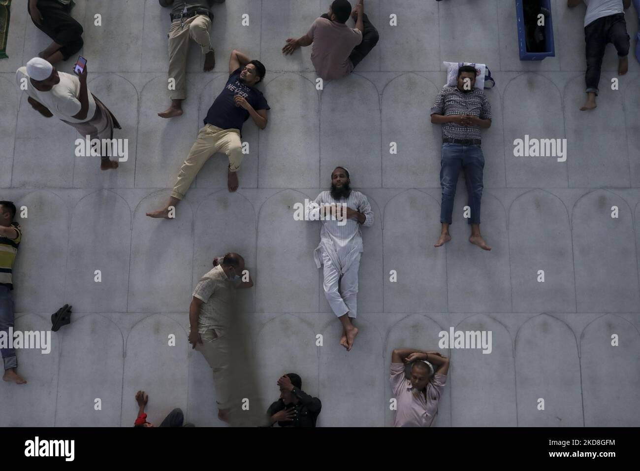 Exhausted Muslim lye down on the mosque floor as they are fasting