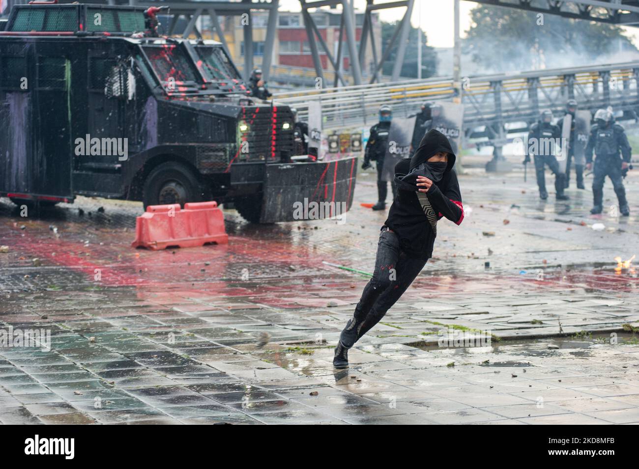 A demonstrator runs away from a riot tank during the 28 of April commemorative demonstrations against the government of president Ivan Duque and violence at Universidad Nacional de Colombia, demonstrators took the closed campus of the University to clash. On April 28, 2022, in Bogota, Colombia (Photo by Sebastian Barros/NurPhoto) Stock Photo