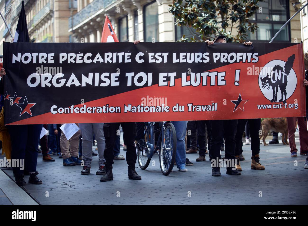 The banner reads 'Our precarity is their profits. Organize yourself and fight'. For May Day or Labour Day, thousands of people took to the streets in Toulouse. Trade unionists, people, yellow vests, anarchists and memebers of the 'Union populaire' came to the demonstration. this year, people are worried of what newly re-elected frecnh president Emmanuel Macon will do during his mandate and are ready to campaign for the election of the legislative body in June. Toulouse. France. May 1st 2022. (Photo by Alain Pitton/NurPhoto) Stock Photo