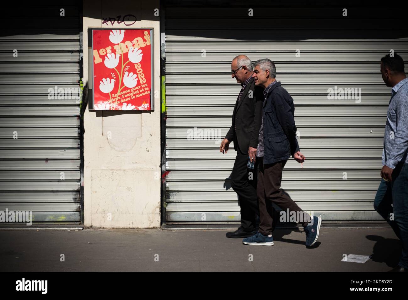 Demonstrators walk past May Day posters stuck up by the CGT union during the traditional May Day demonstration in Paris (Labor Day) marking International Workers Day, starting at Place de la République in Paris, May 1, 2022. (Photo by Samuel Boivin/NurPhoto) Stock Photo