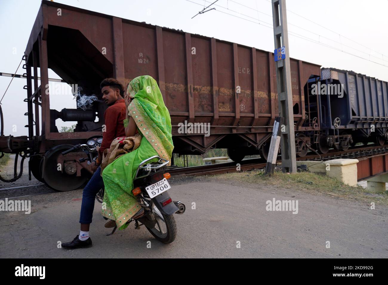 A man smokes a bidi, or hand-rolled tobacco, as he waits for a train carrying coal rakes to pass at a crossing close to the coal-fired thermal Power Plant of National Thermal Power Corporation (NTPC), at Dadri in Gautam Budh Nagar district, Uttar Pradesh, India on May 5, 2022. Amid the rampant rise in power demand due to the prevailing heatwave, India is staring at a coal crisis, with stock critically low at 108 of its 173 thermal power plants. The power cuts are sparking scrutiny of country’s long reliance on coal, which is responsible for about 70% of India's electricity generation. (Photo b Stock Photo