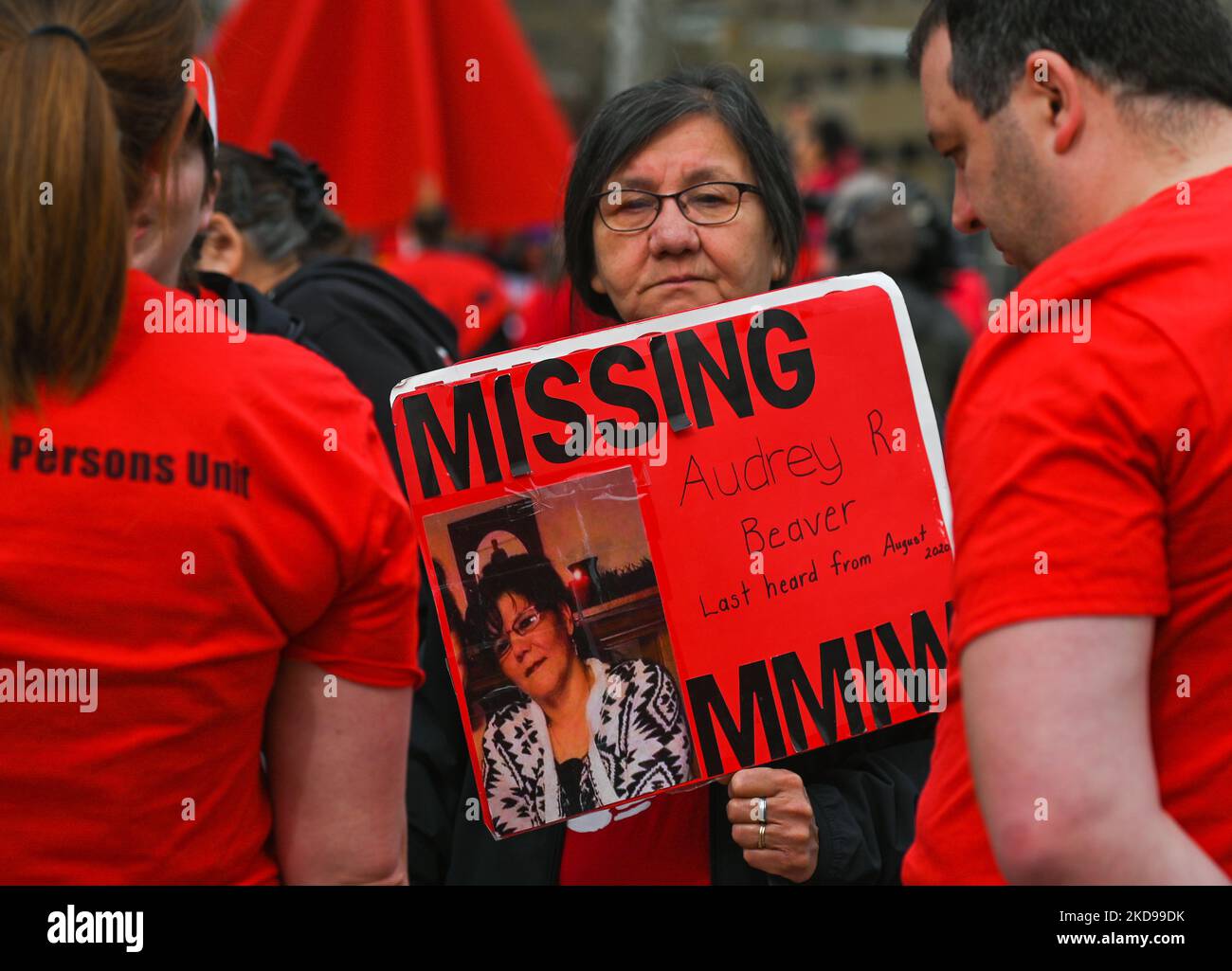 A participant holds a placard with a name of a missing woman. Hundreds
