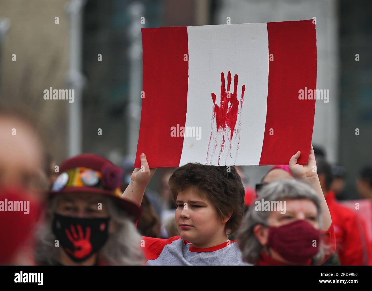A participant holds a Canadian flag. Hundreds of women participated in the annual Red Dress Day march in downtown Edmonton, hosted by Project REDress, commemorating the lives of missing and murdered indigenous women and girls across Canada. On Thursday, 5 May 2022, in Edmonton, Alberta, Canada. (Photo by Artur Widak/NurPhoto) Stock Photo