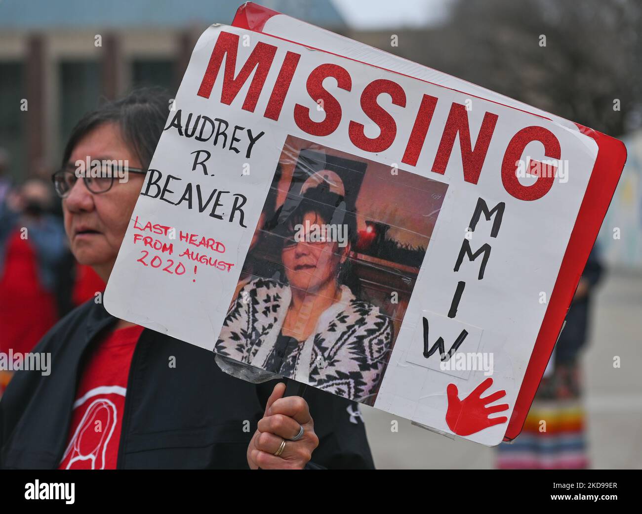 A participant holds a placard with a name of a missing woman. Hundreds
