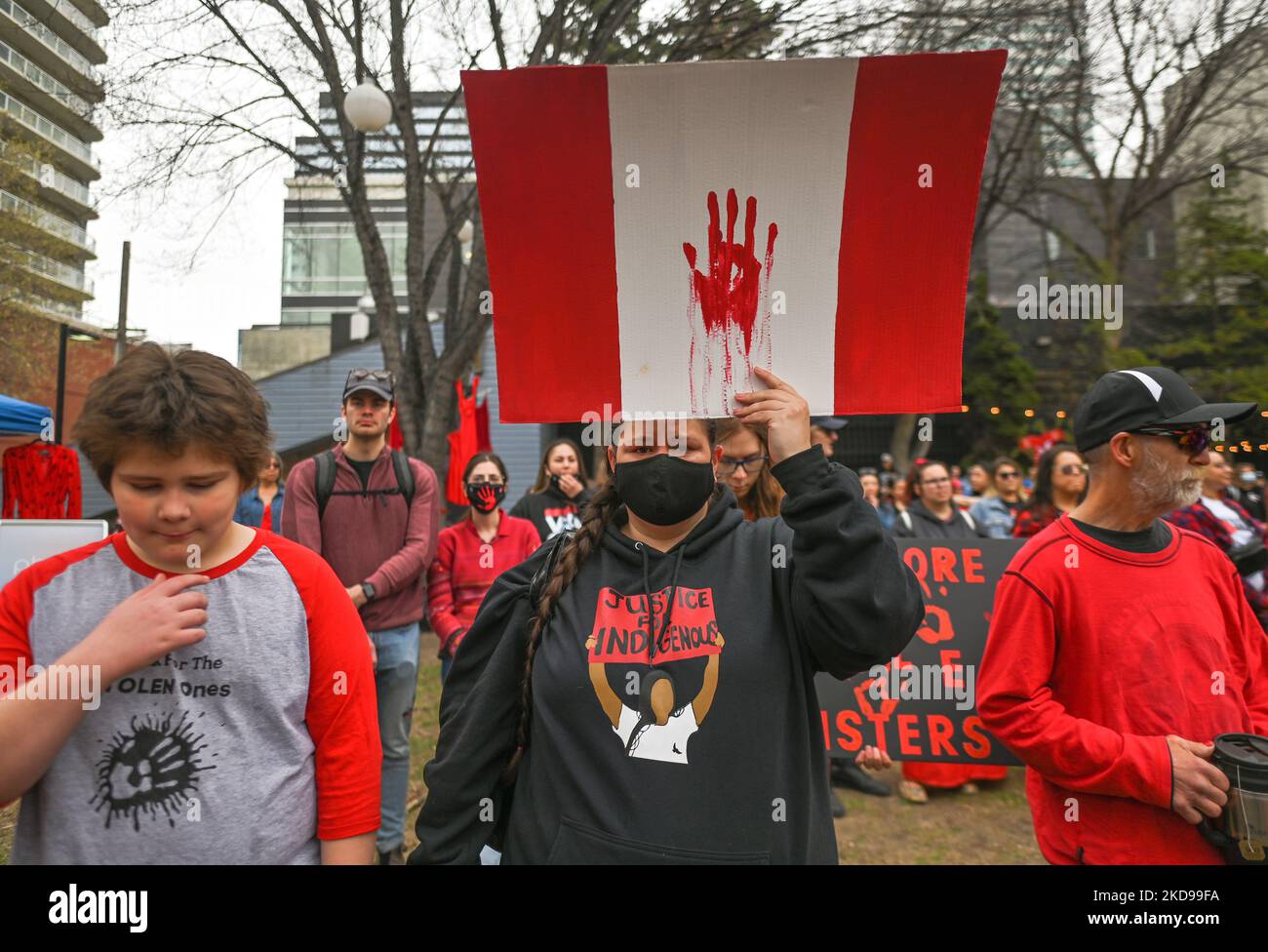 A participant holds a Canadian flag. Hundreds of women participated in the annual Red Dress Day march in downtown Edmonton, hosted by Project REDress, commemorating the lives of missing and murdered indigenous women and girls across Canada. On Thursday, 5 May 2022, in Edmonton, Alberta, Canada. (Photo by Artur Widak/NurPhoto) Stock Photo