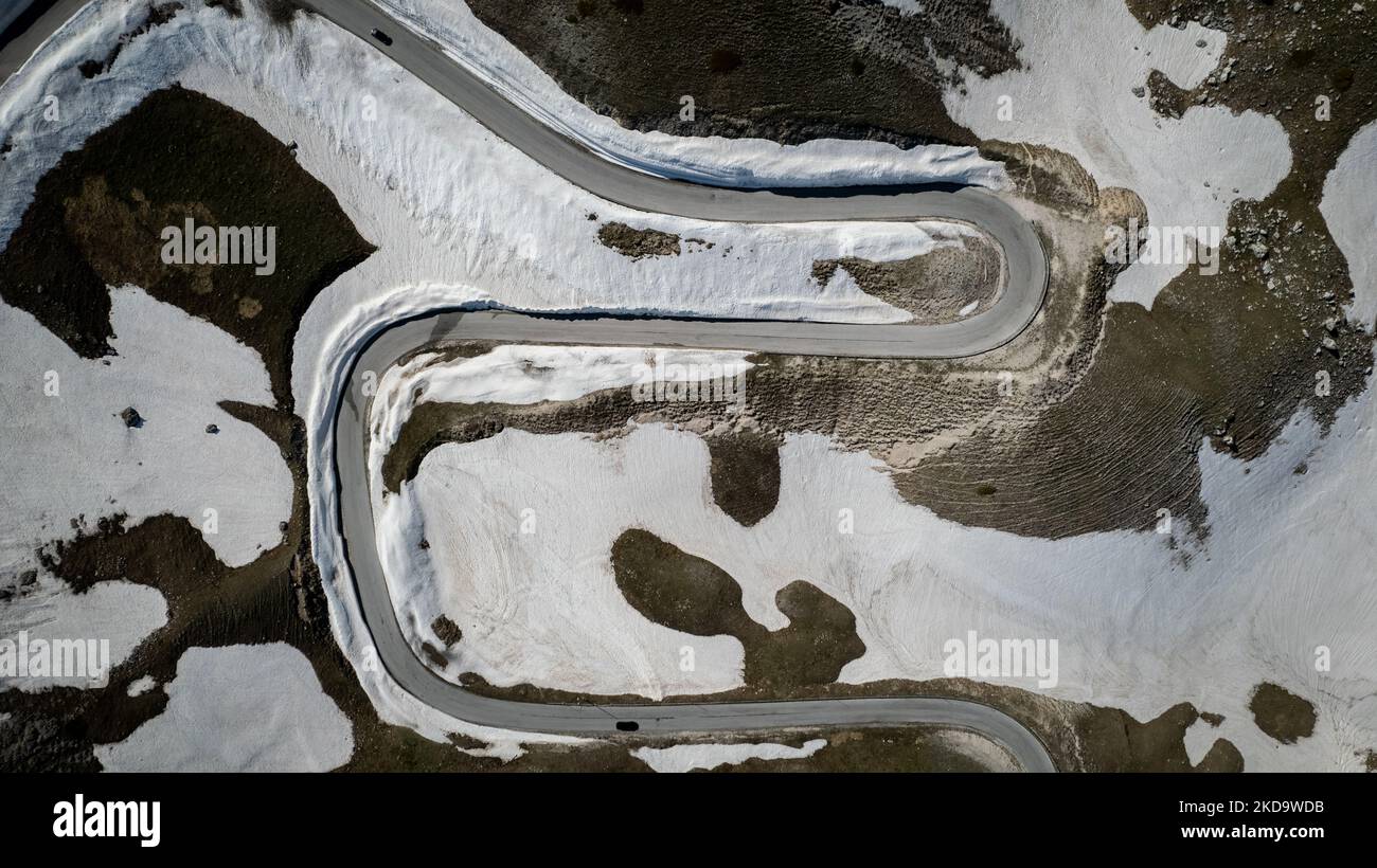 A drone view of a road with snow on the ridges in Campo Imperatore in the Gran Sasso and Laga Mountains National Park, on May 13, 2022. -Gran Sasso d'Italia is a massif in the Apennine Mountains of Italy. Its highest peak, Corno Grande (2,912 metres), is the highest mountain in the Apennines, and the second-highest mountain in Italy outside the Alps. (Photo by Manuel Romano/NurPhoto) Stock Photo
