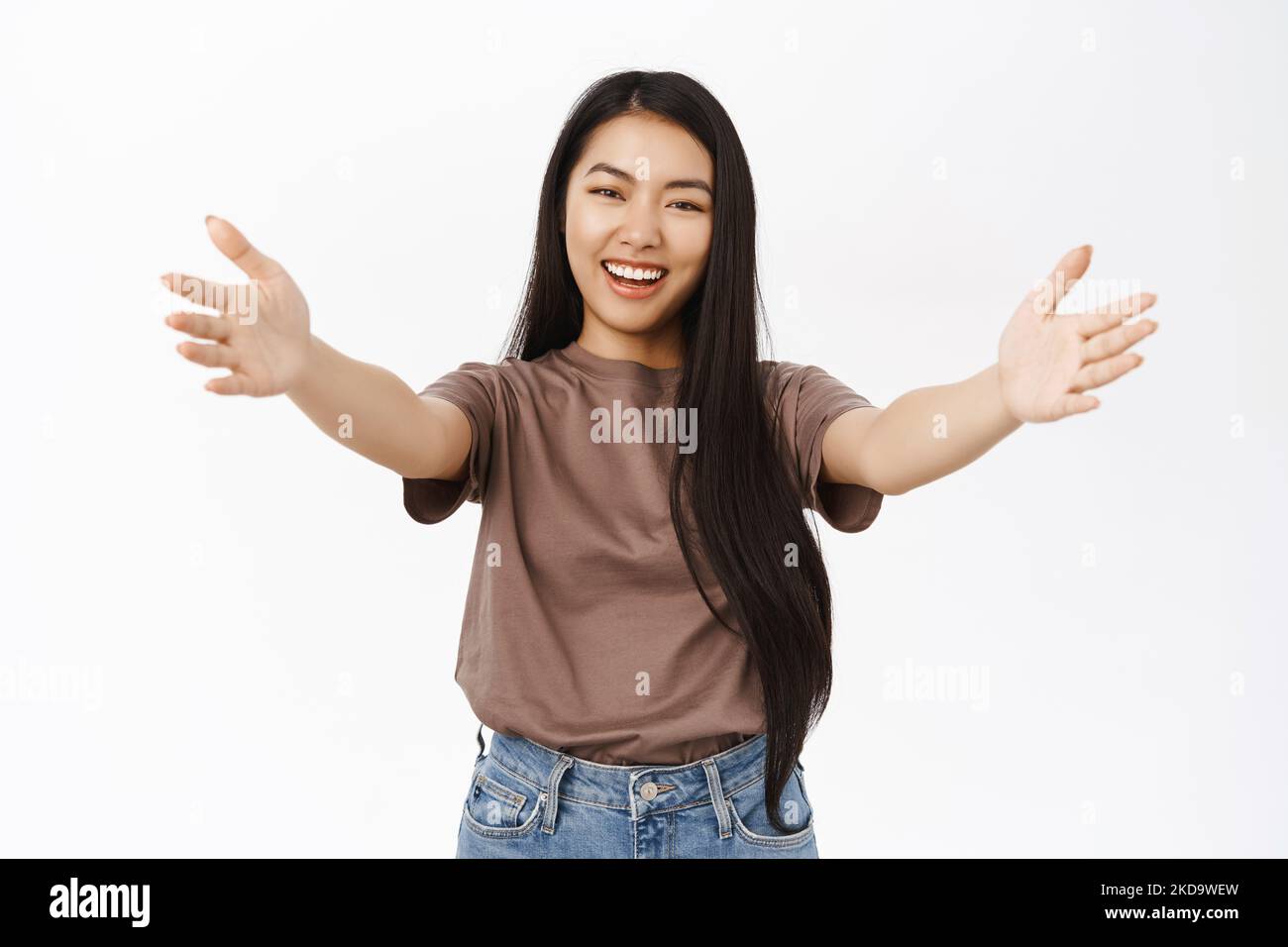 Beautiful asian woman extending hand, spread arms for hug,