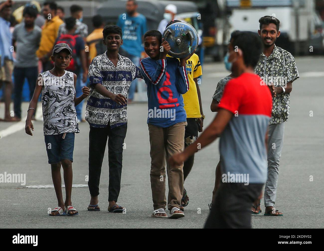 A boy carries an Empty cooking gas cylinder to a distribution center in
