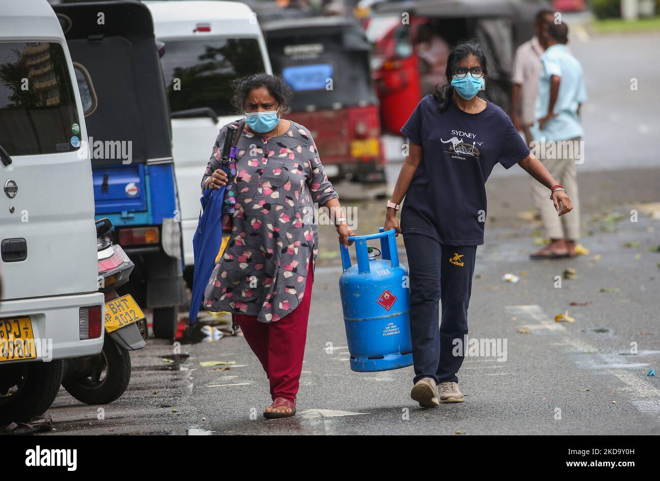 Women carry an Empty cooking gas cylinder to a distribution center in Colombo, Sri Lanka, May 14