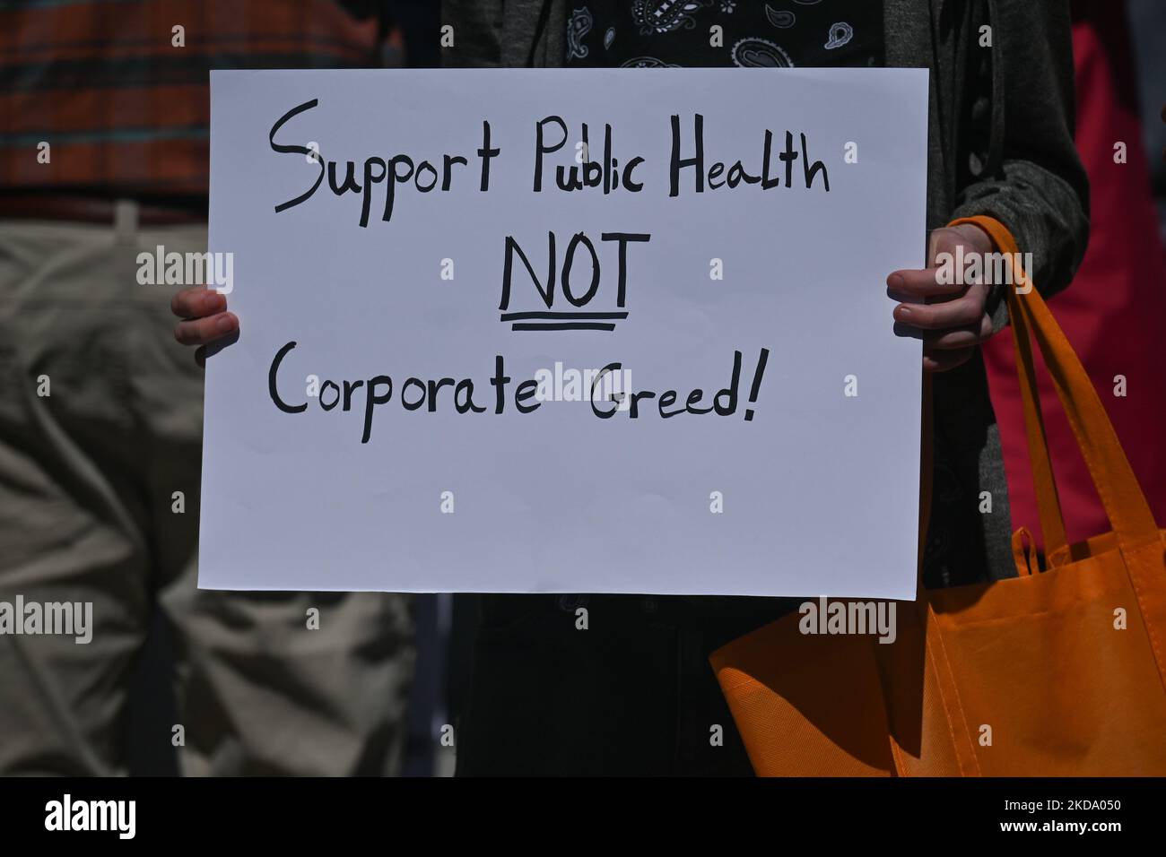 A protester holds a placard with words 'Support Public Health Care NIOT Corporate Greed!'. Health-care workers, activists and their supporters protested this afternoon during 'Rally for Public Health Care' at the Alberta Legislature, in Edmonton, against Premier Kenney and the UCP government that are taking steps to privatize health care. On Saturday, 14 May 2022, in Edmonton, Alberta, Canada. (Photo by Artur Widak/NurPhoto) Stock Photo