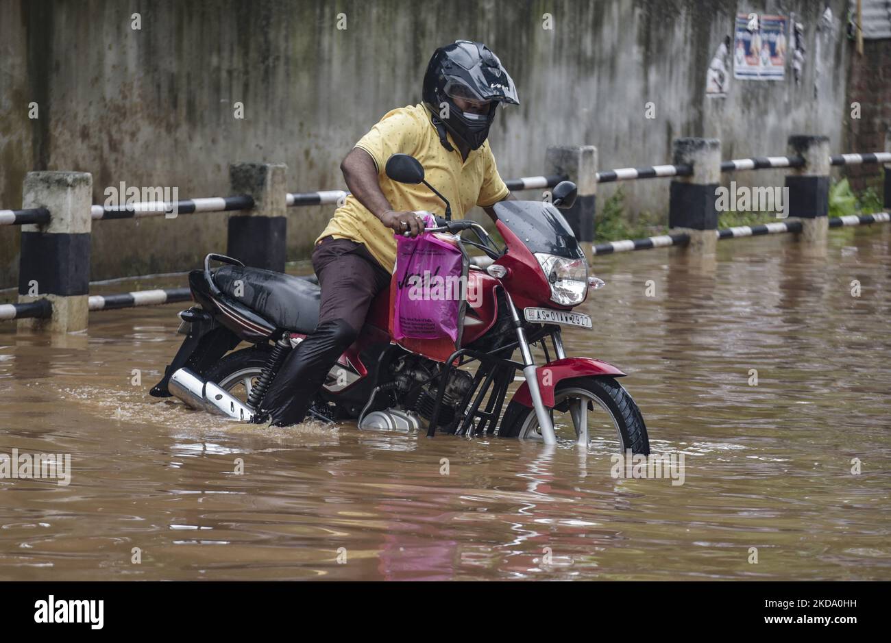 Commuters Make Their Way On A Waterlogged Street After A Heavy Rainfall In Guwahati Assam