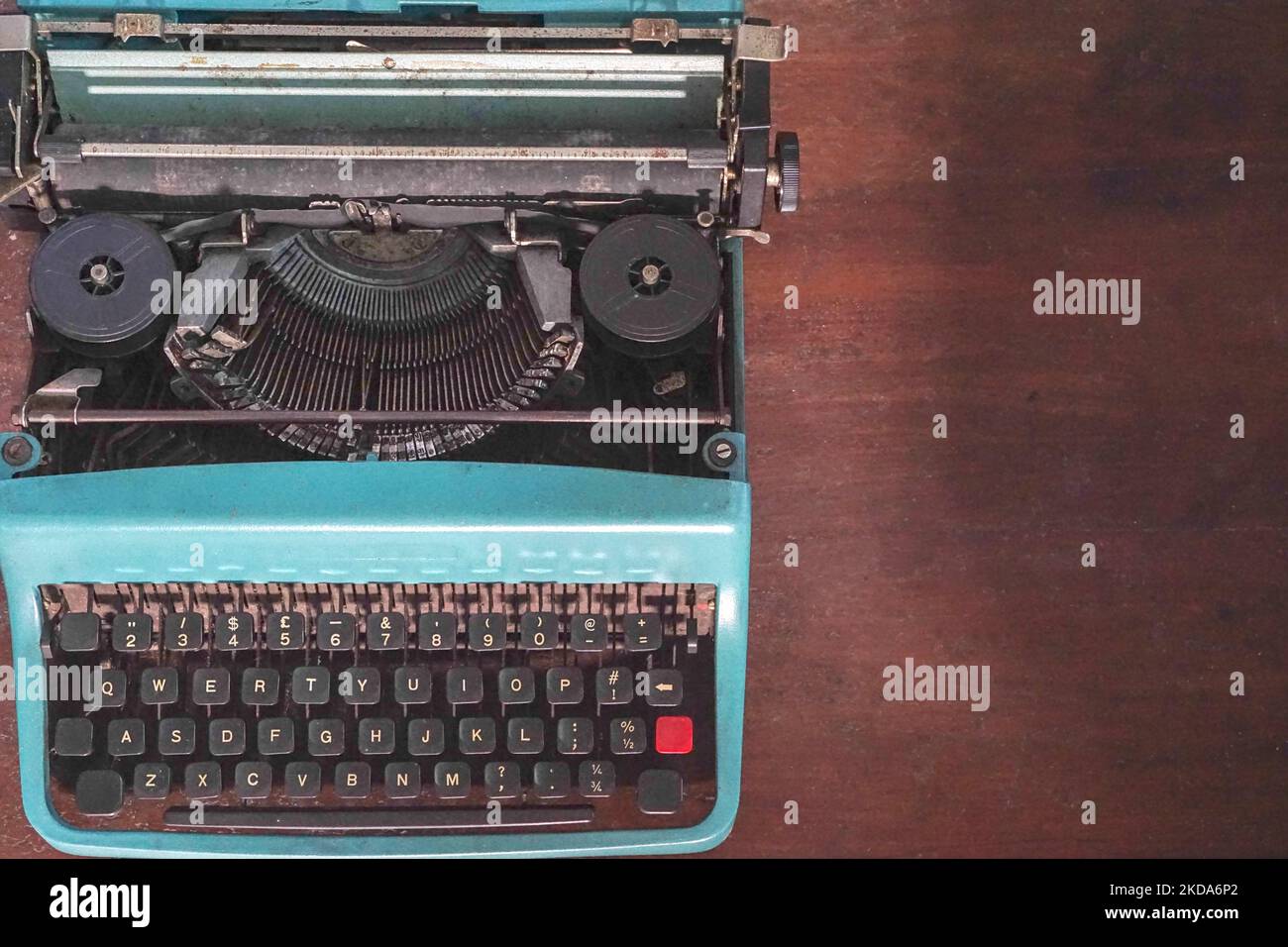 An old blue typewriter with a blank space for text isolated on brown background Stock Photo