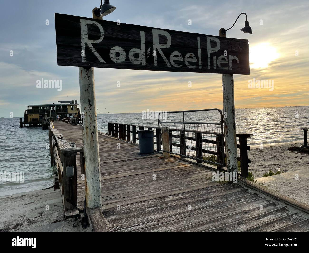 The fishing pier against the background of the sea and sky at sunset