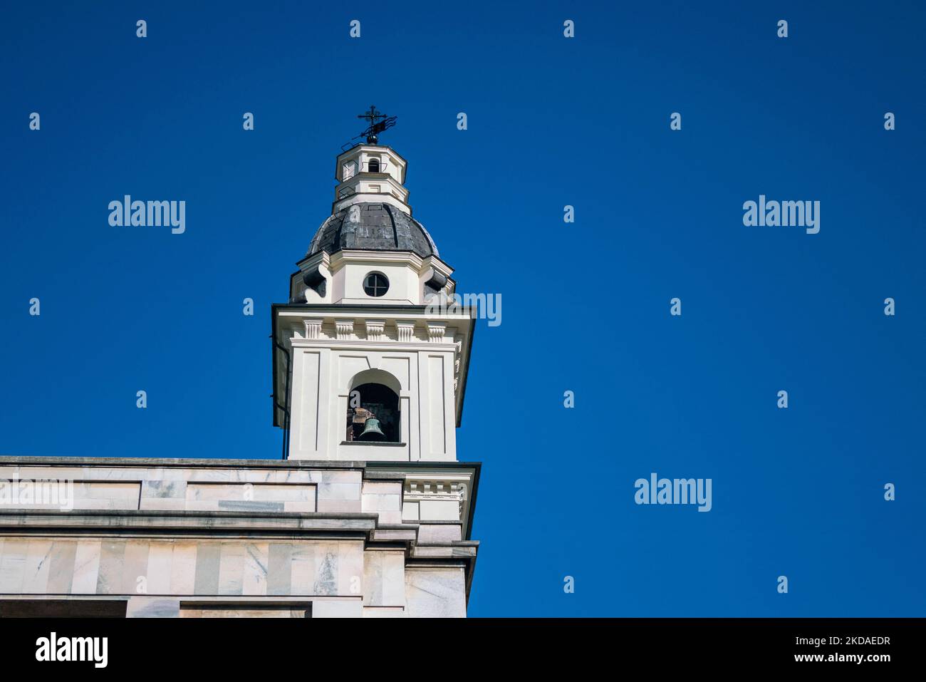 architecture: bell tower in the sky, exposed baroque bell tower and dome with cross and weather vane. Stock Photo