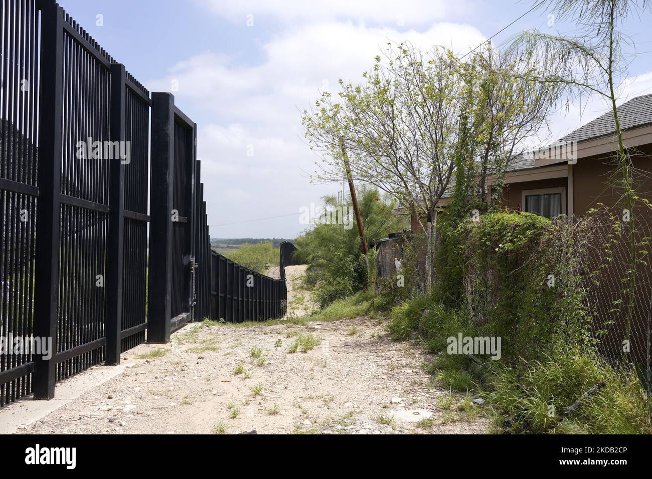The Border Wall passes through a residential neighborhood on May 27 2022 in Eagle Pass Texas, USA. Title 42, the Trump era mandate which was set to prevent migrants from entering the US, was to expire on May 23 but was blocked by a lawsuit filed by several states citing that the move to strike down the law “failed to meet standards set by the Administrative Procedure Act” and that there is no permanent solution to handling the inevitable surge in immigration. Opponents to upholding of the law voiced their demands stating that Title 42 is illegal in that it violates immigration laws that preven Stock Photo
