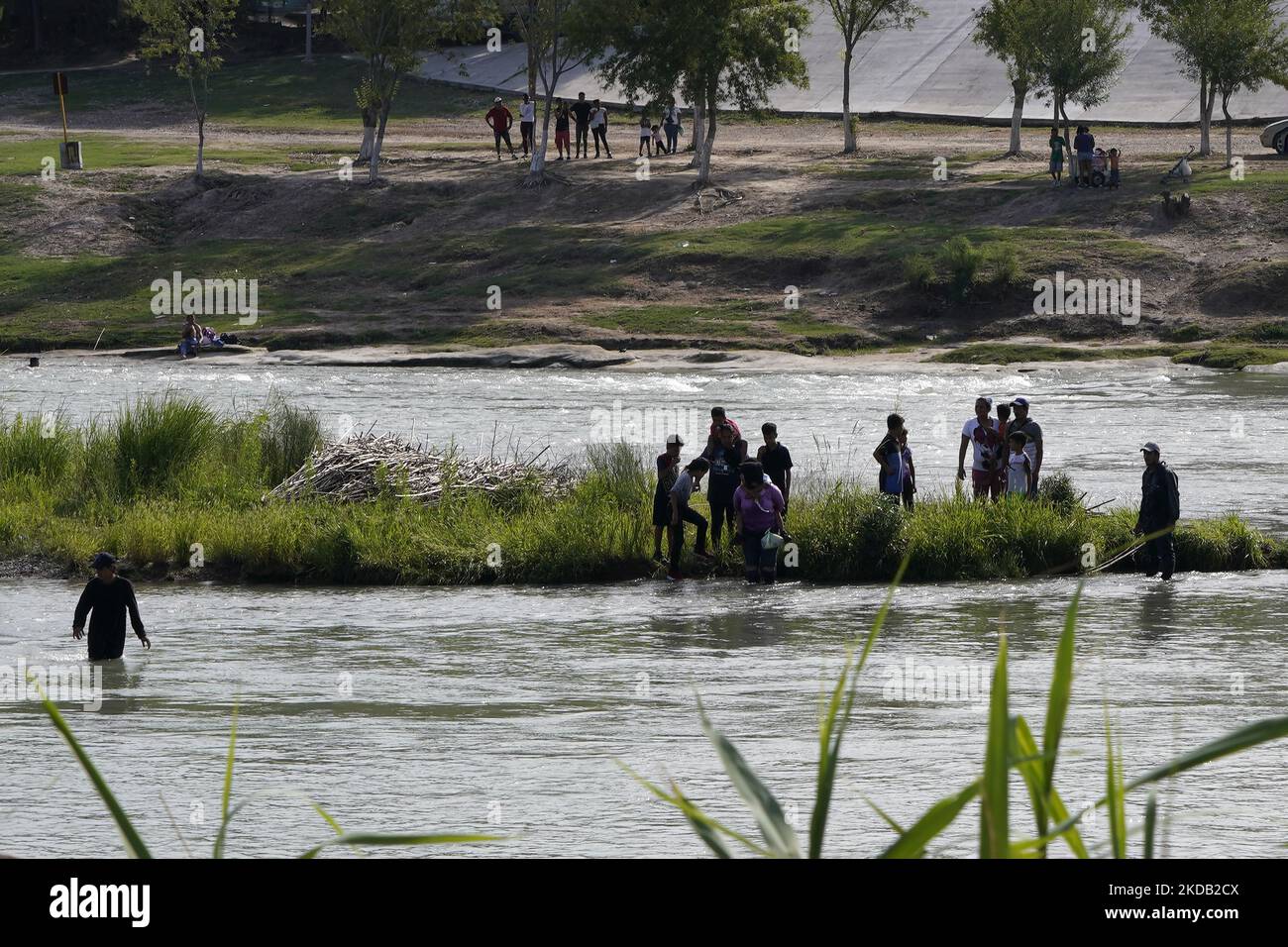 Migrants, some aided by handlers, cross the Rio Grande on May 27 2022 in Eagle Pass Texas, USA. Title 42, the Trump era mandate which was set to prevent migrants from entering the US, was to expire on May 23 but was blocked by a lawsuit filed by several states citing that the move to strike down the law “failed to meet standards set by the Administrative Procedure Act” and that there is no permanent solution to handling the inevitable surge in immigration. Opponents to upholding of the law voiced their demands stating that Title 42 is illegal in that it violates immigration laws that prevents  Stock Photo