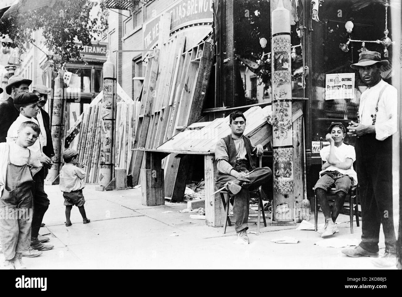 Men and boys on sidewalk outside of store, at festival in Little Italy, New York City. Usa in 1908 Stock Photo