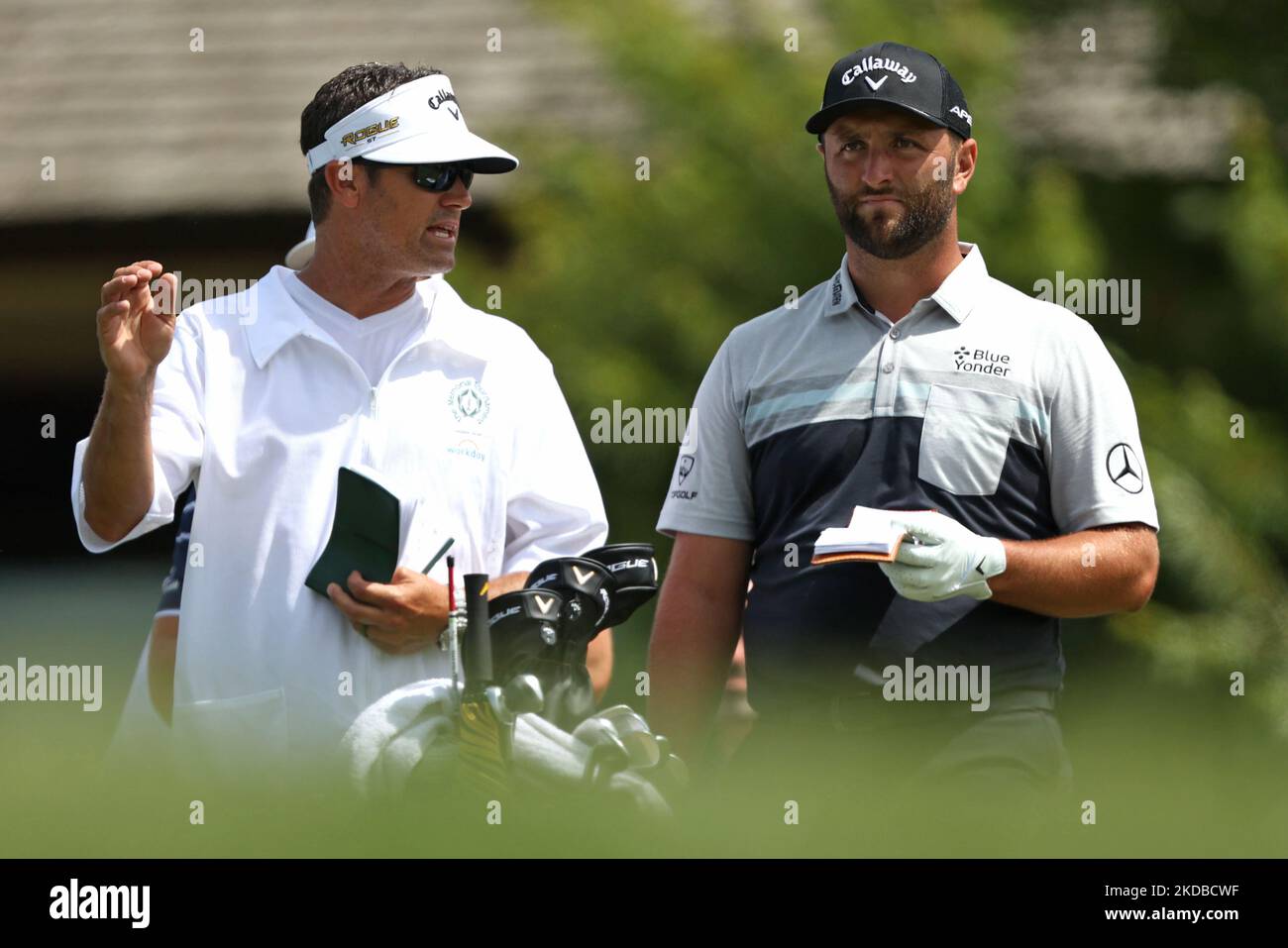 Jon Rahm of Spain interacts with his caddy on the 10th tee during the