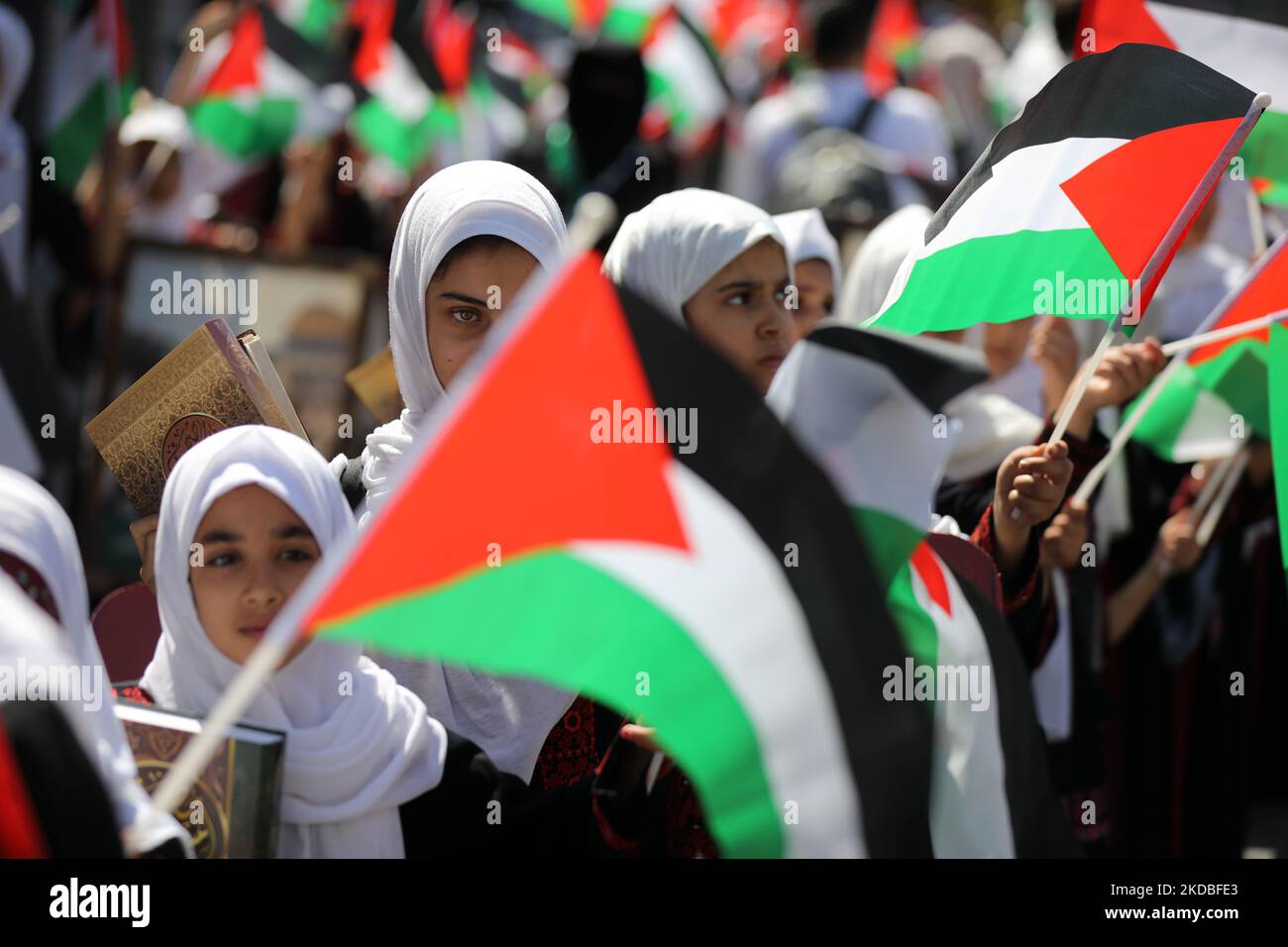 Palestinian girls wave national flags and the Holy Quran during a march to start a summer camp organized by the Hamas movement, in Gaza City, on June 04, 2022. (Photo by Majdi Fathi/NurPhoto) Stock Photo