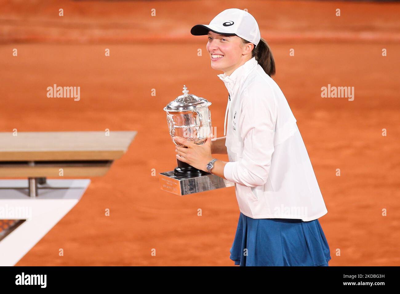 Iga Swiatek posing for photos with the trophy of Roland Garros after