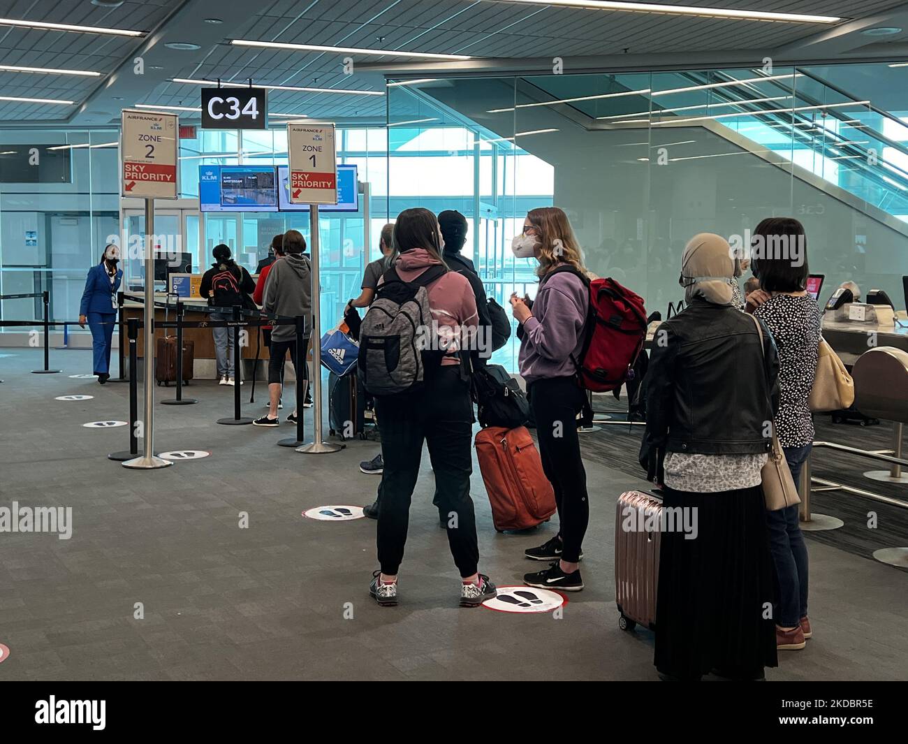 Travelers wearing face masks while waiting to board a flight during the