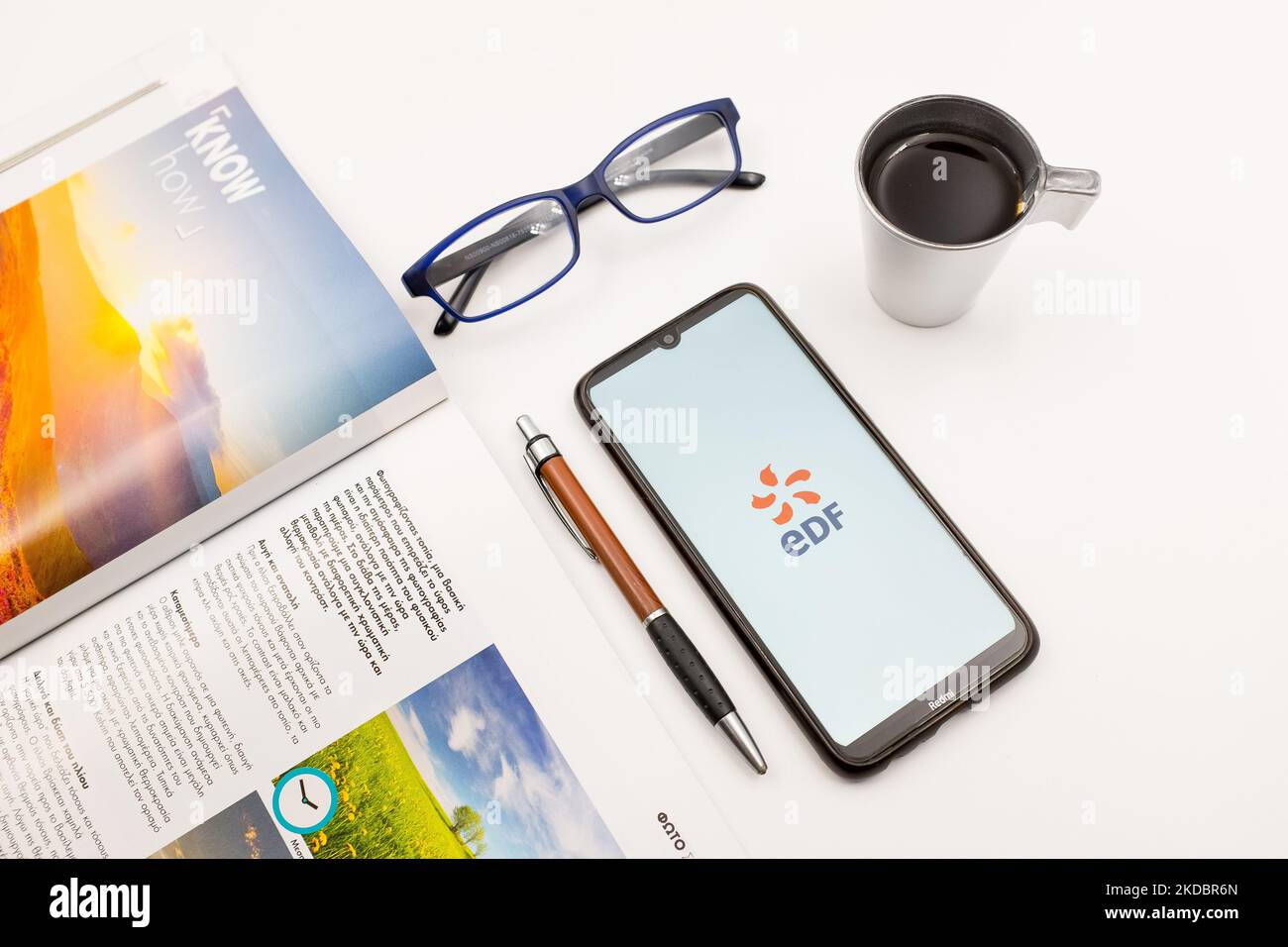 In this photo illustration an Electricite de France (EDF)logo seen displayed on a smartphone screen on a desk next to a cafe, a pen, glasses and a magazine in Athens, Greece on June 9, 2022. (Photo illustration by Nikolas Kokovlis/NurPhoto) Stock Photo