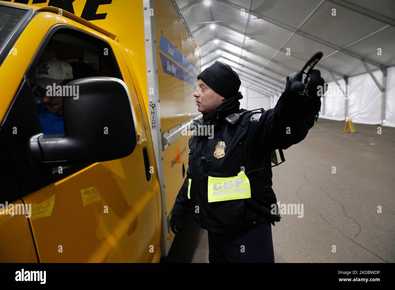 A U.S. Customs and Border Protection, Office of Field Operations, officer gestures as he directs the driver of a truck where to stand shortly before X-raying the vehicle during non-intrusive inspections prior to Super Bowl LII in Minneapolis, Minn., Jan. 30, 2018. On Sunday, Feb. 4, the Philadelphia Eagles will face off against the New England Patriots for the NFL championship title. U.S. Customs and Border Protection photo by Glenn Fawcett Stock Photo