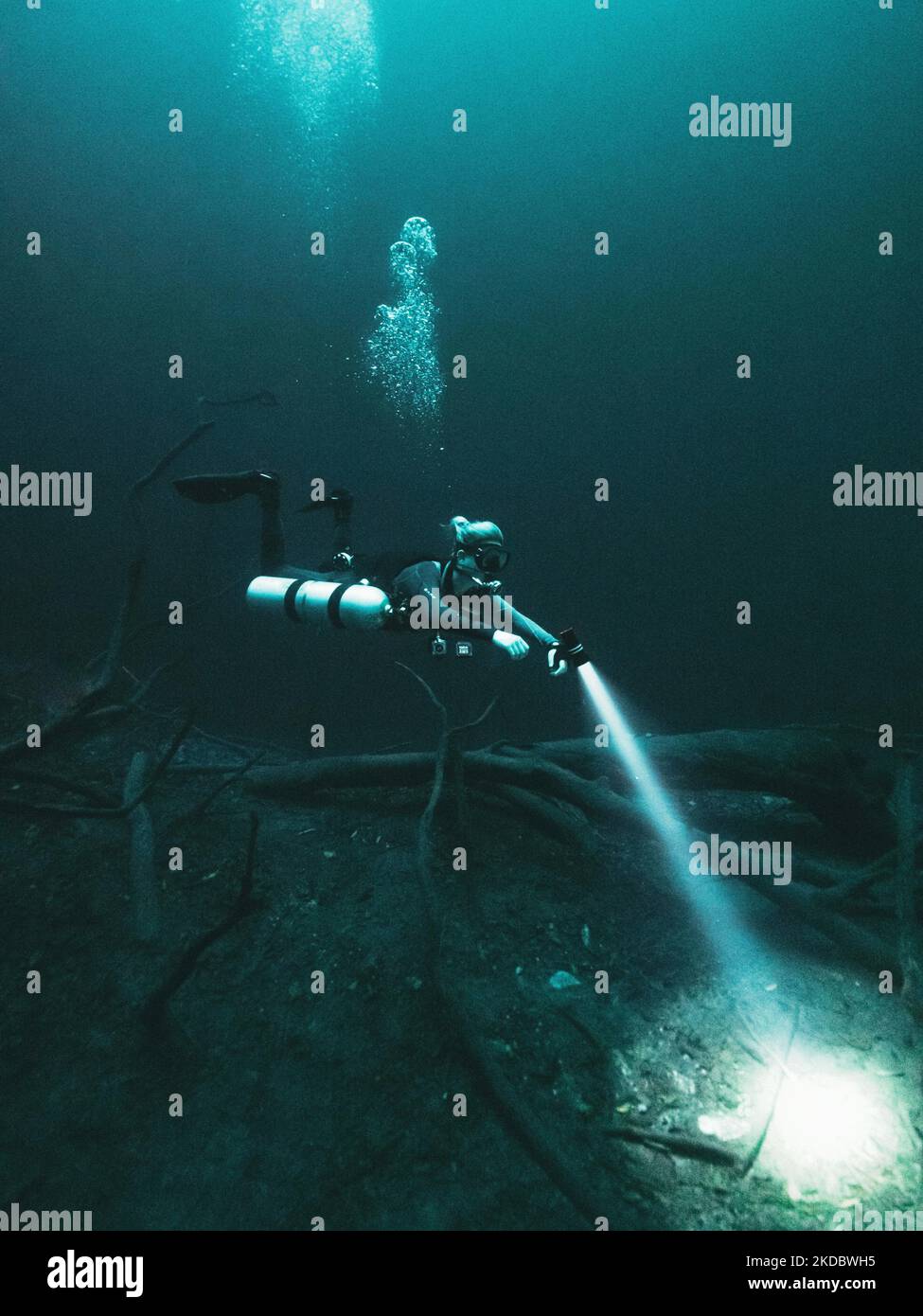 A scuba diver wandering in the blue mysterious water, in a vertical