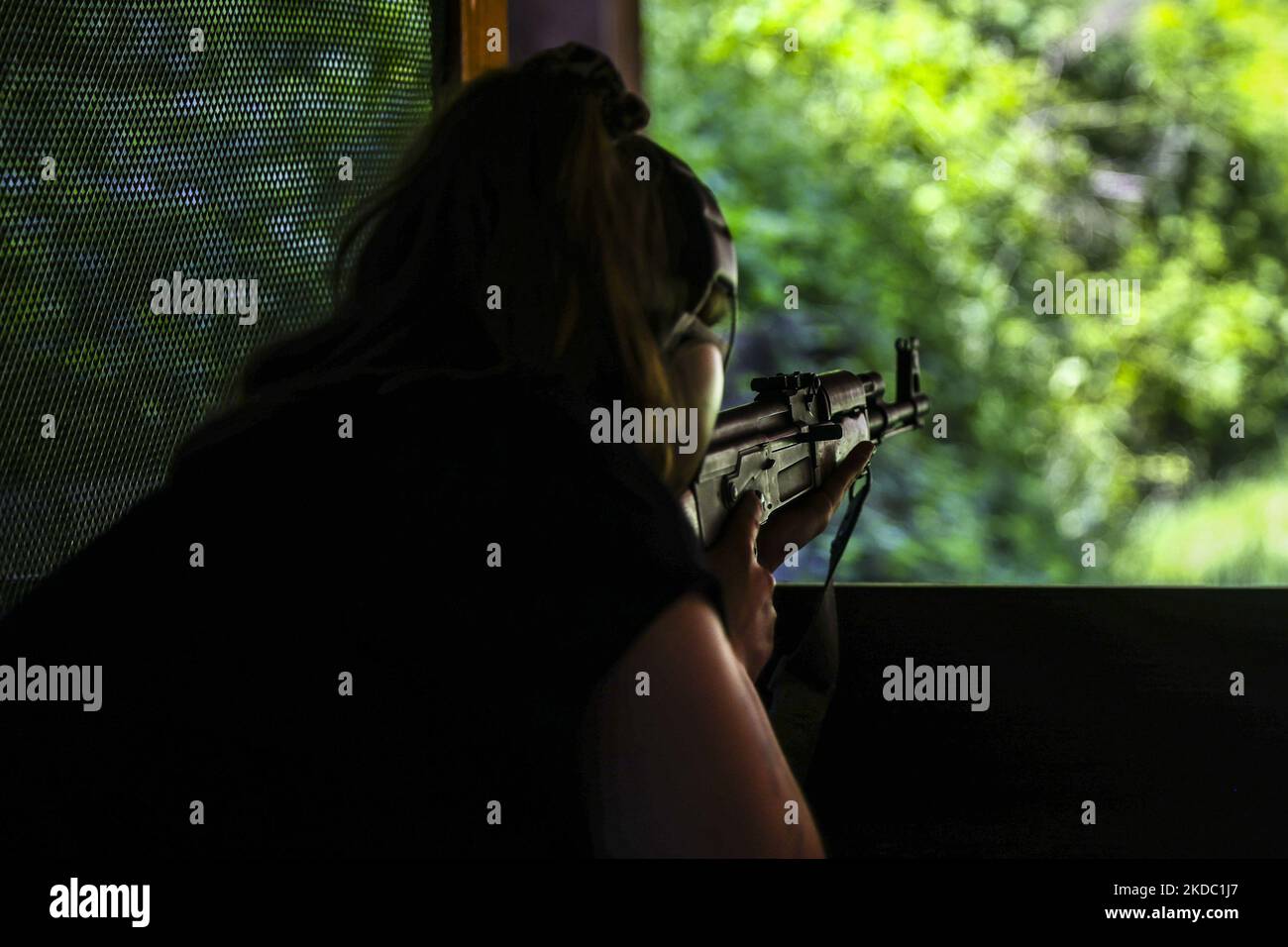 A woman is shooting AK47 Kalashnikov rifle at LOK HTS Shooting CLub