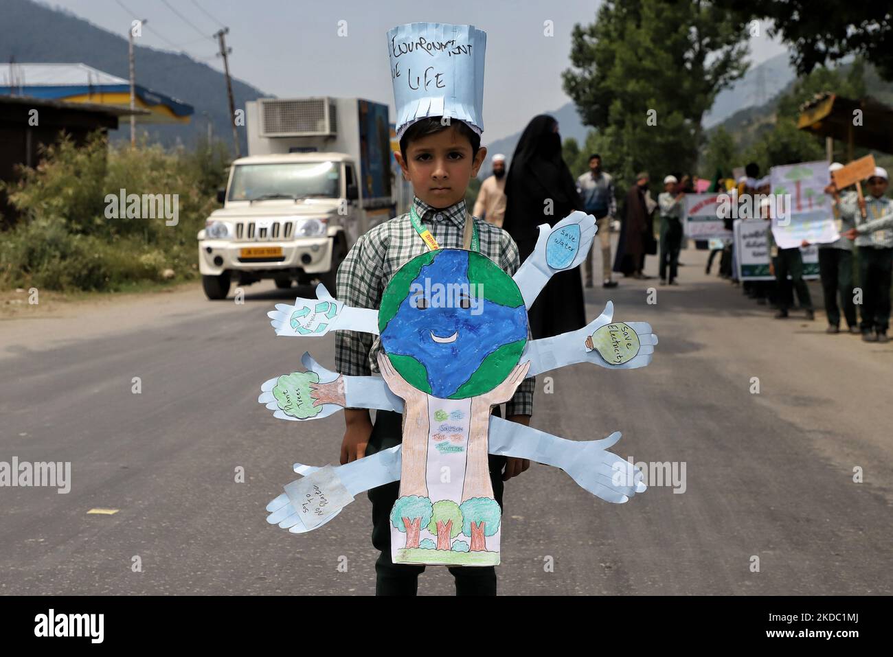 A school boy takes Part in environmental day holds a banner which reads Plant Trees, Save Water, Save Electricity, say no to plastic in Baramulla Jammu and Kashmir India on 13 June 2022. (Photo by Nasir Kachroo/NurPhoto) Stock Photo