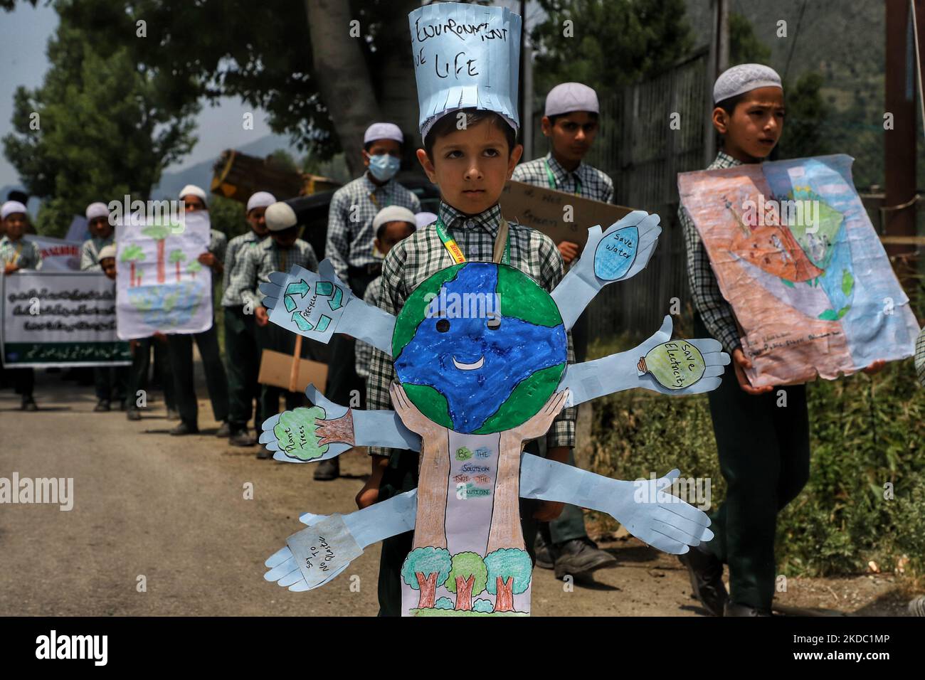 A school boy takes Part in environmental day holds a banner which reads Plant Trees, Save Water, Save Electricity, say no to plastic in Baramulla Jammu and Kashmir India on 13 June 2022. (Photo by Nasir Kachroo/NurPhoto) Stock Photo