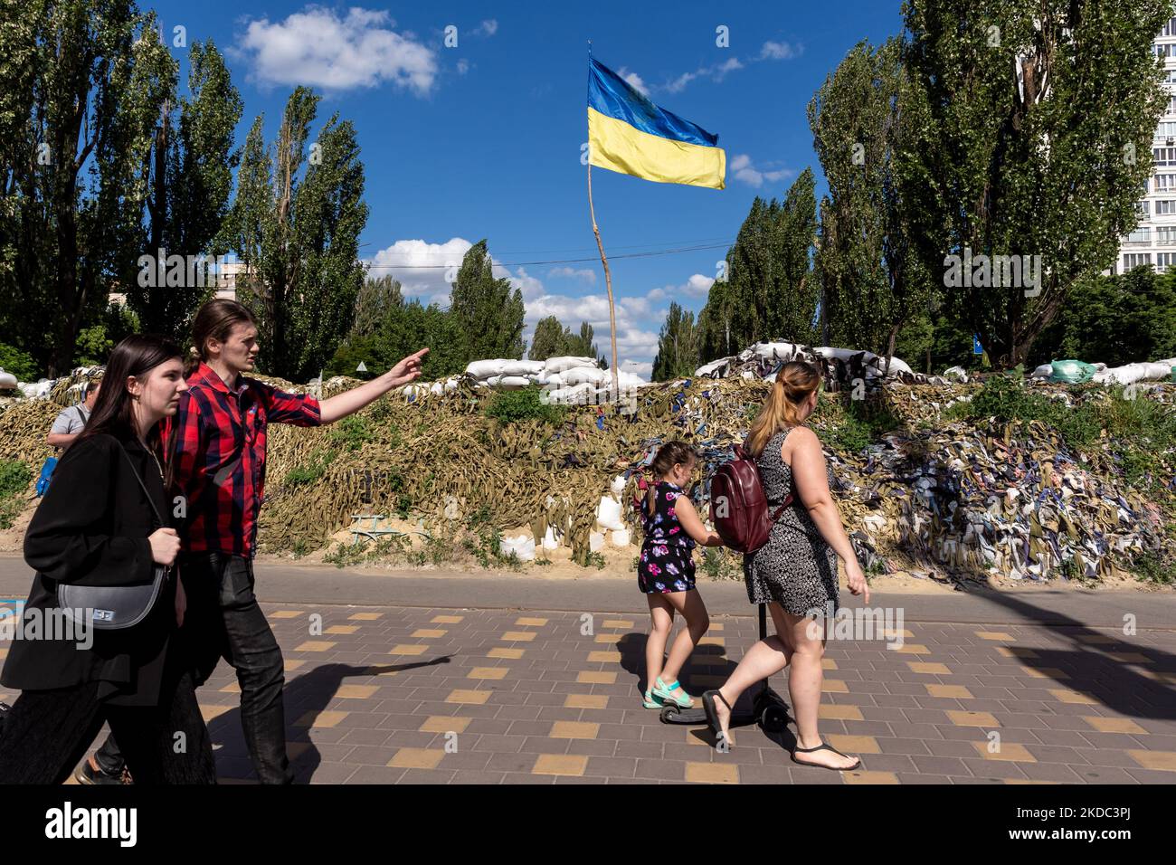 TPeople are seen walking in fron of Ukainian flag in Kiev, Ukraine on June 14, 2022. As the Russian Federation invaded Ukraine more than 3 and a half months ago, fierce fighting continues in the East of the country. Some of the most devastated towns since the beginning of the conflict - Irpin and Bucha - build their way to normality. More and more civilians get back to their homes and reestablish their lives. (Photo by Dominika Zarzycka/NurPhoto) Stock Photo